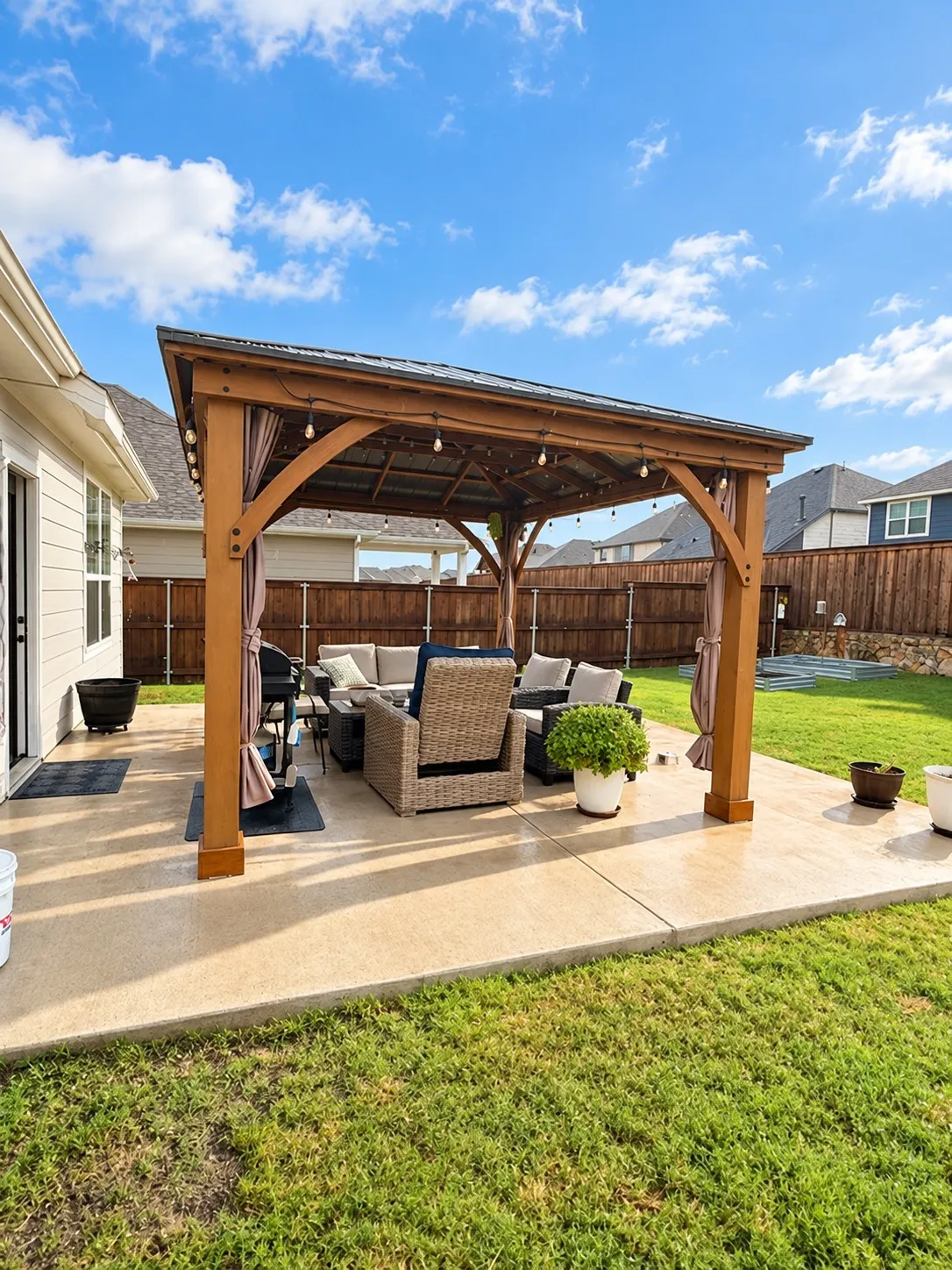 Expansive concrete patio featuring a wood-frame pergola with a metal roof