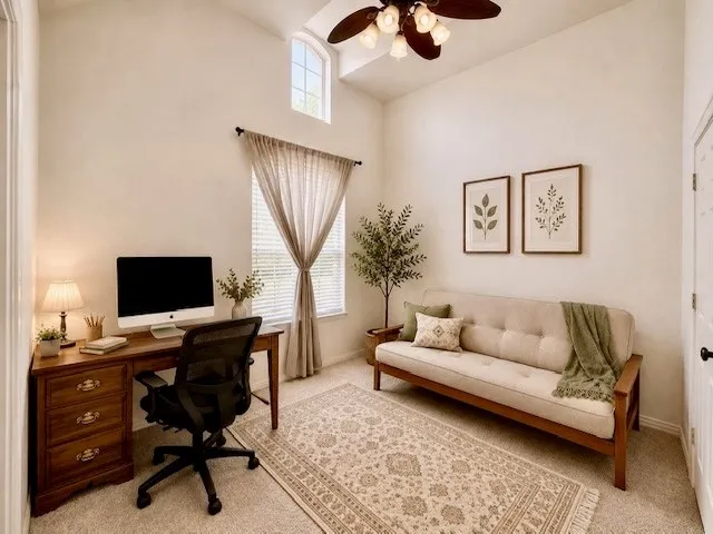 Vaulted ceiling, arched transom window, large window with blinds, ceiling fan, and light-toned wall finishes