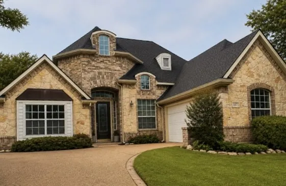 Stone and brick exterior with a dark shingle roof