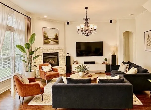 Stone-clad fireplace, wood-finish flooring, recessed lighting, arched entryway, and a multi-arm chandelier