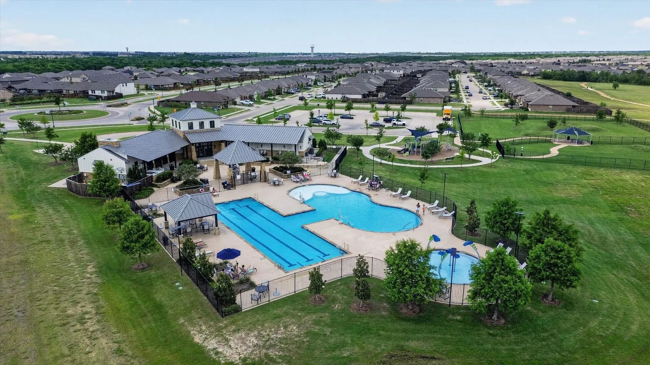 Community clubhouse with multiple swimming pools, including a lap pool and a splash pad