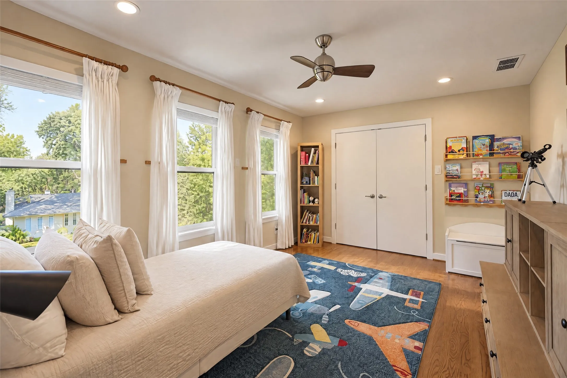 Hardwood flooring and recessed lighting illuminate the room