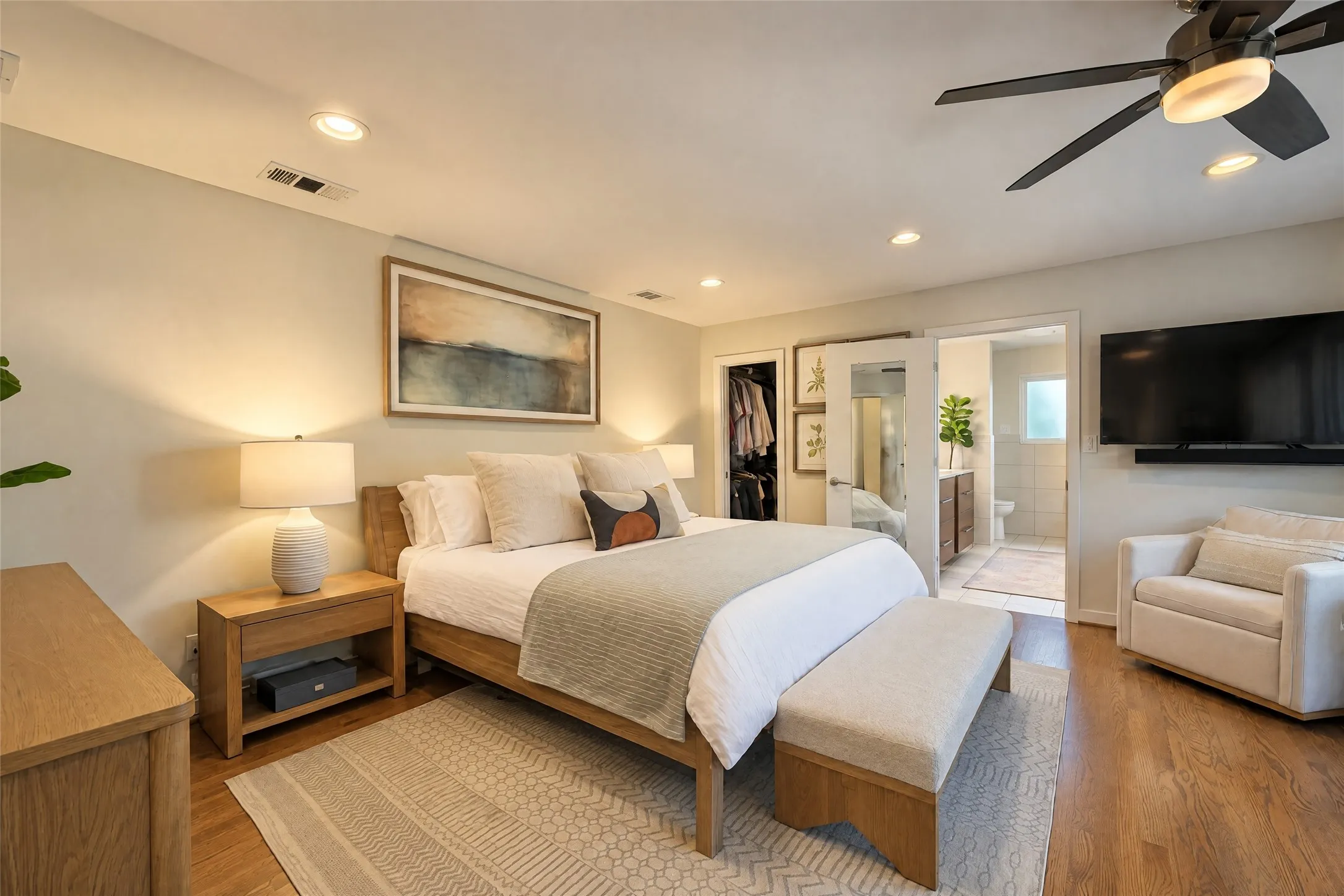 Recessed ceiling lighting, wood-finish flooring, a ceiling fan with integrated lighting, and a closet with bifold mirrored doors