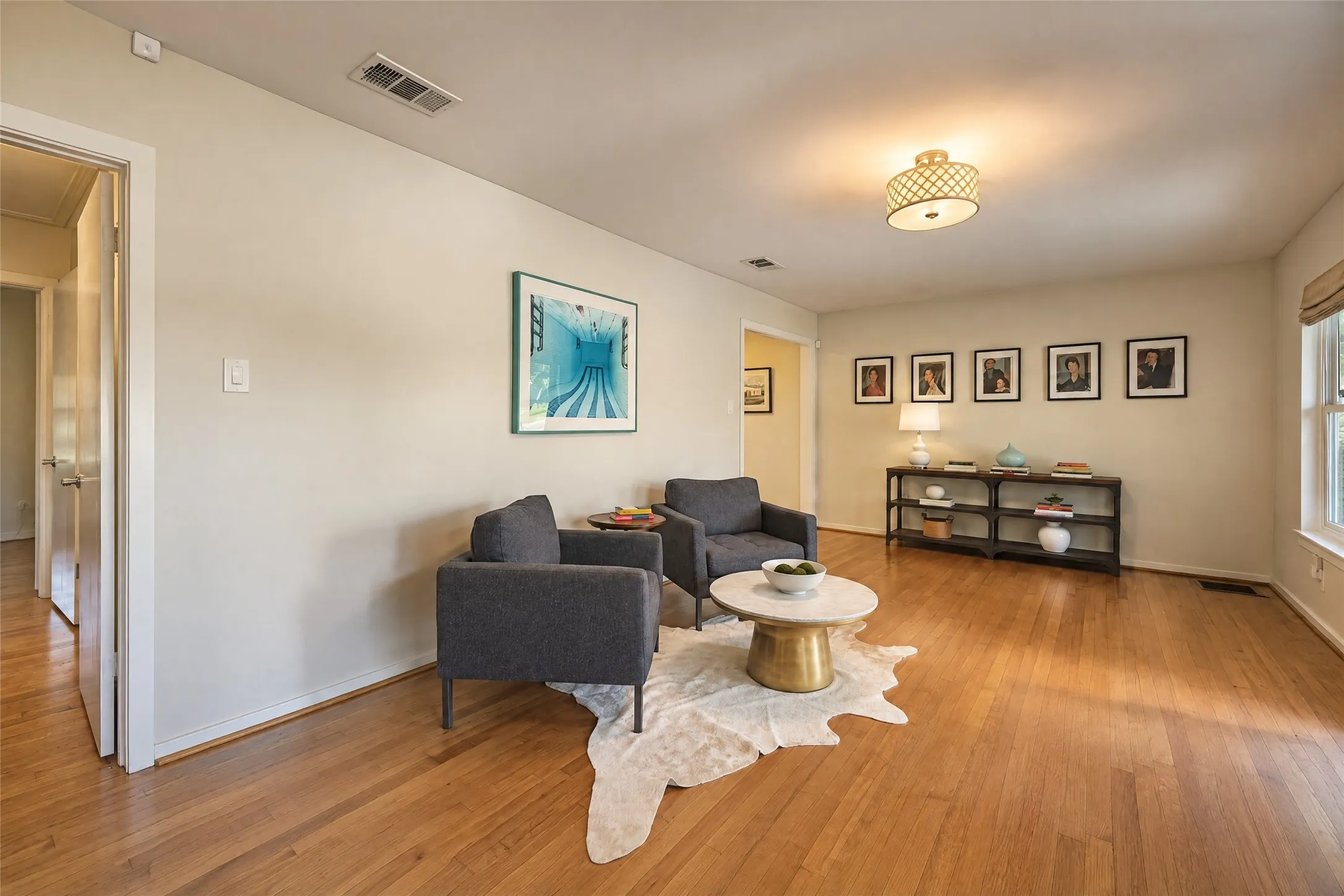 Hardwood flooring throughout, recessed lighting, and a window with roller shade
