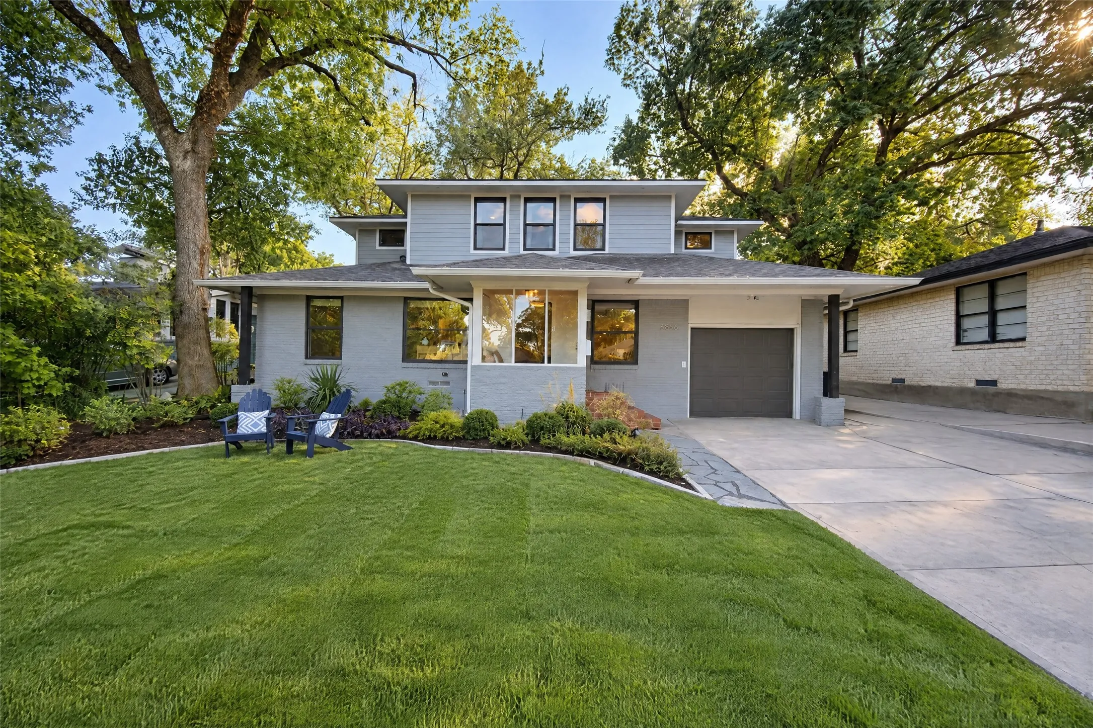 Modern exterior with light gray siding and dark trim windows