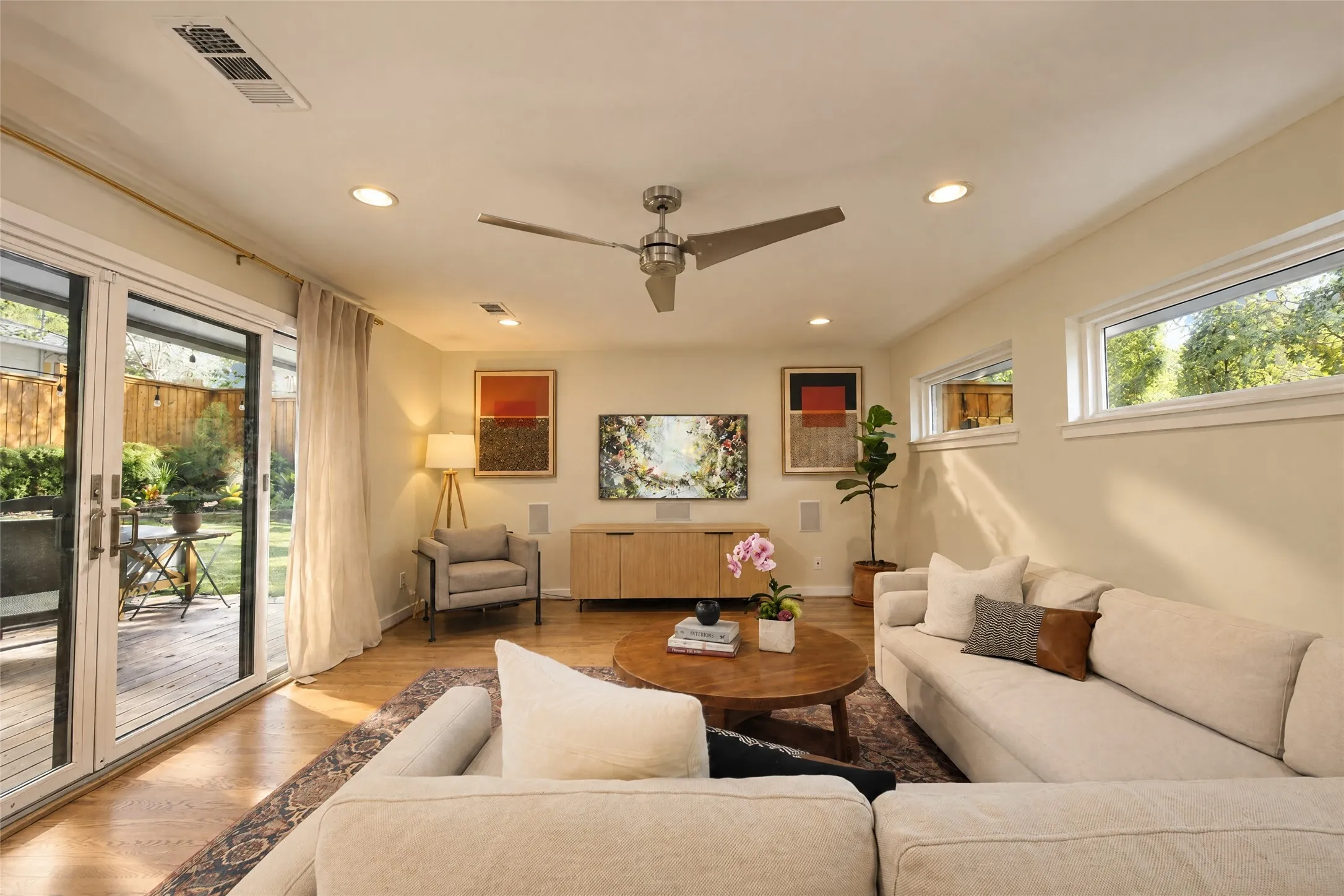 Wood-finish flooring with recessed lighting and a ceiling fan