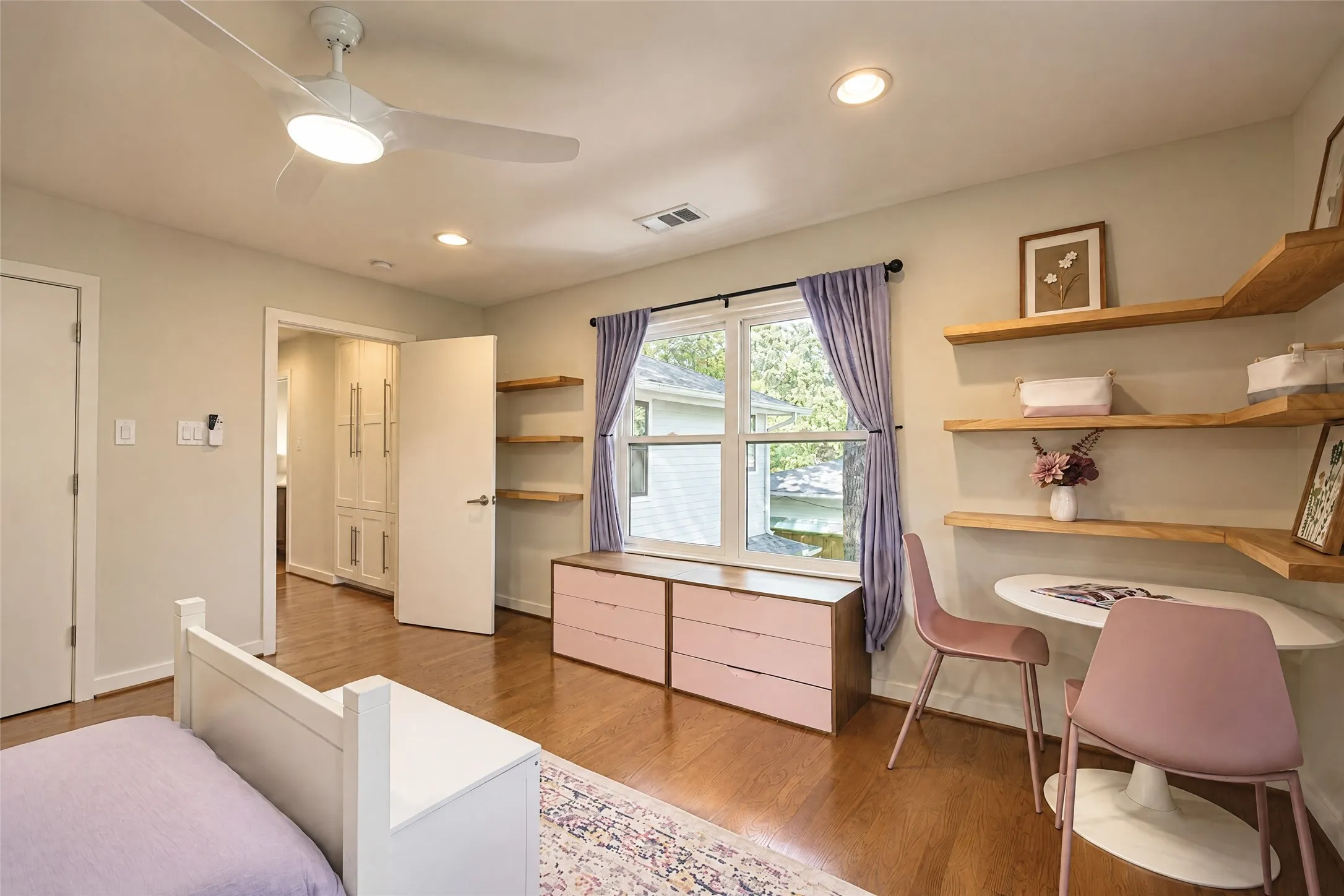 Hardwood flooring, recessed lighting, ceiling fan with integrated light, built-in shelving, and a built-in window bench