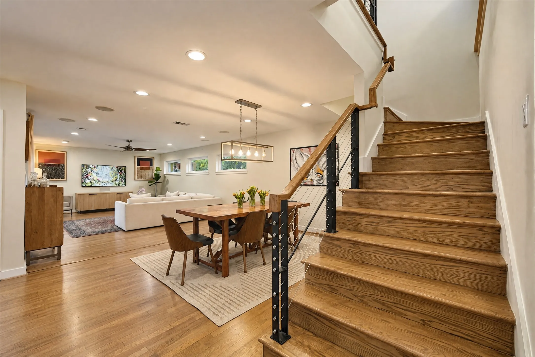 Hardwood flooring, recessed lighting, and a modern staircase with cable railing