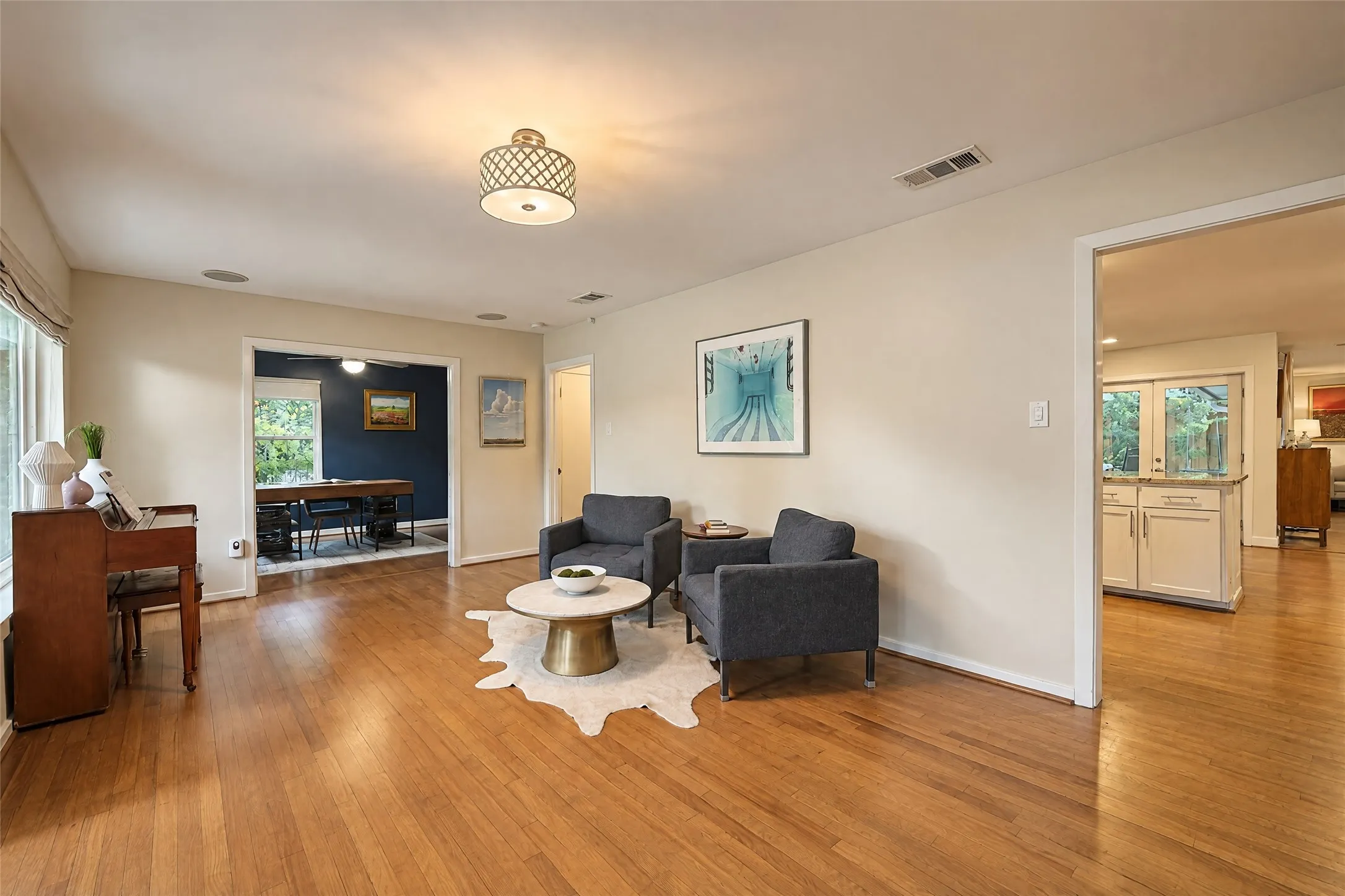 Hardwood flooring throughout, recessed ceiling lighting, and a drum-style ceiling fixture