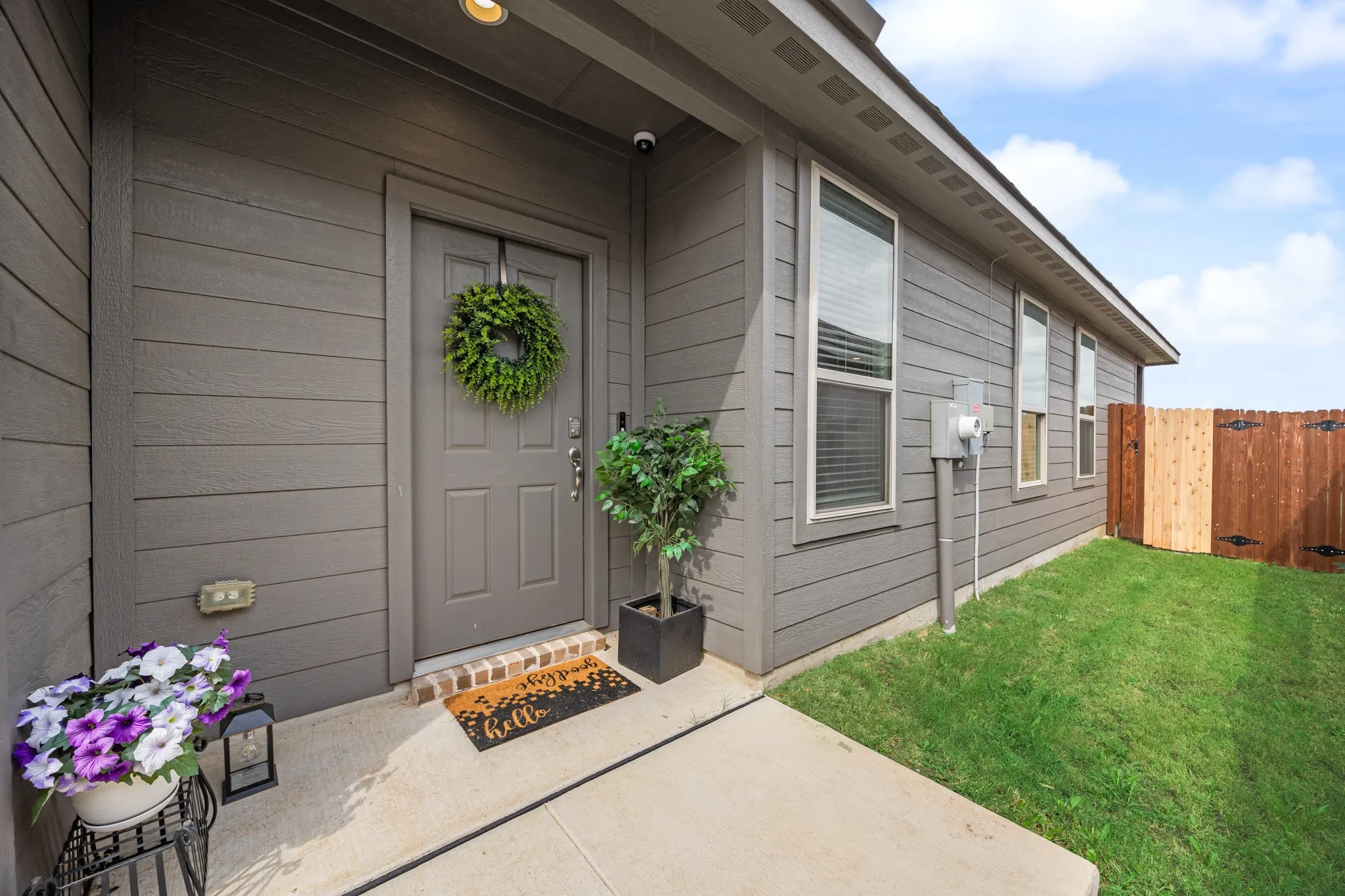 Exterior featuring horizontal siding, a covered entry, a paneled front door, and a concrete walkway