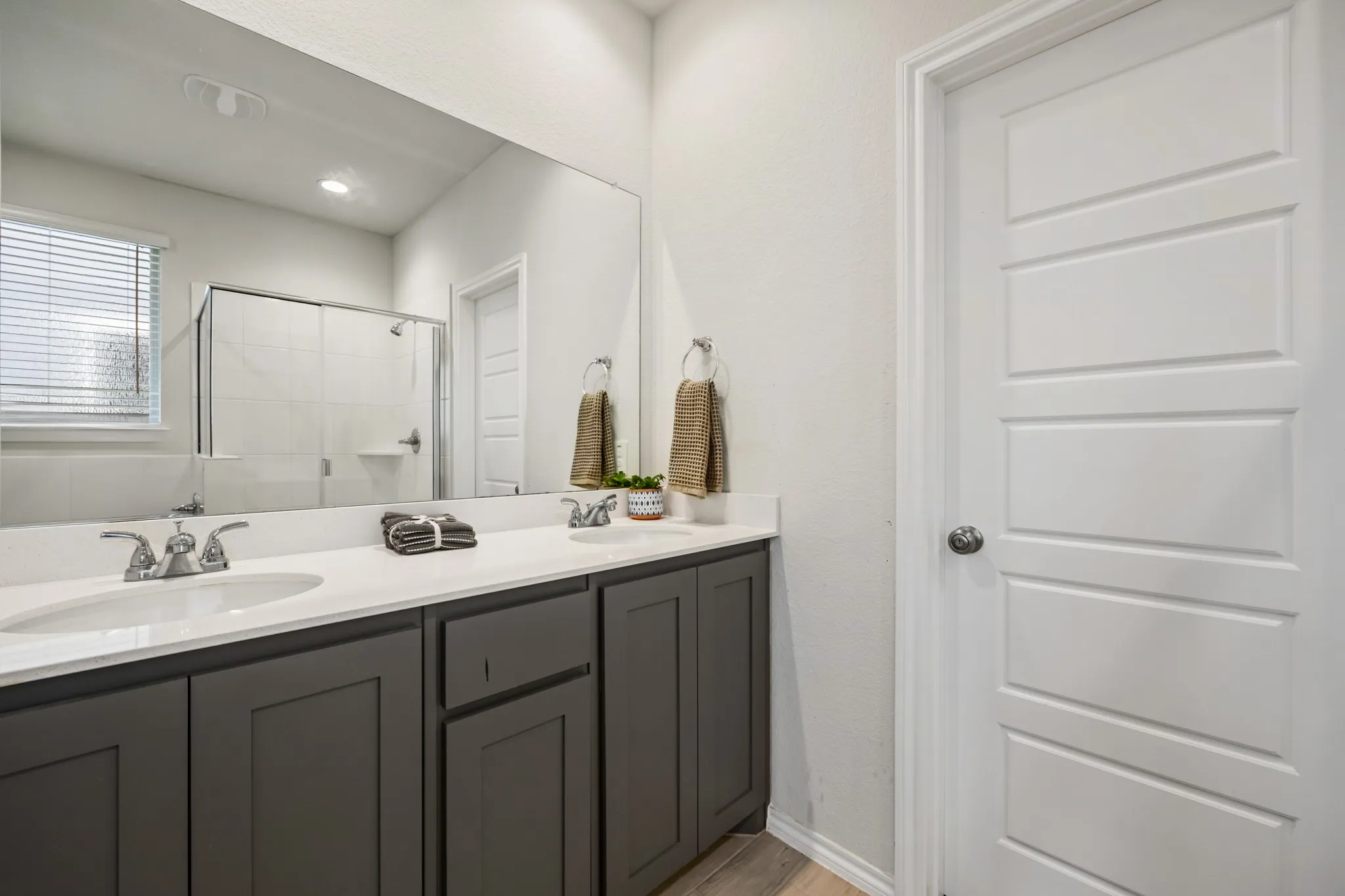 Dual vanity with gray cabinetry, white countertops, and chrome fixtures