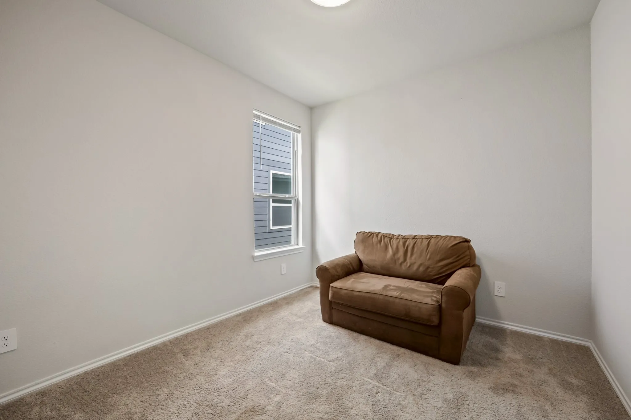 Wall-to-wall carpeting, neutral wall finishes, and a single window with blinds