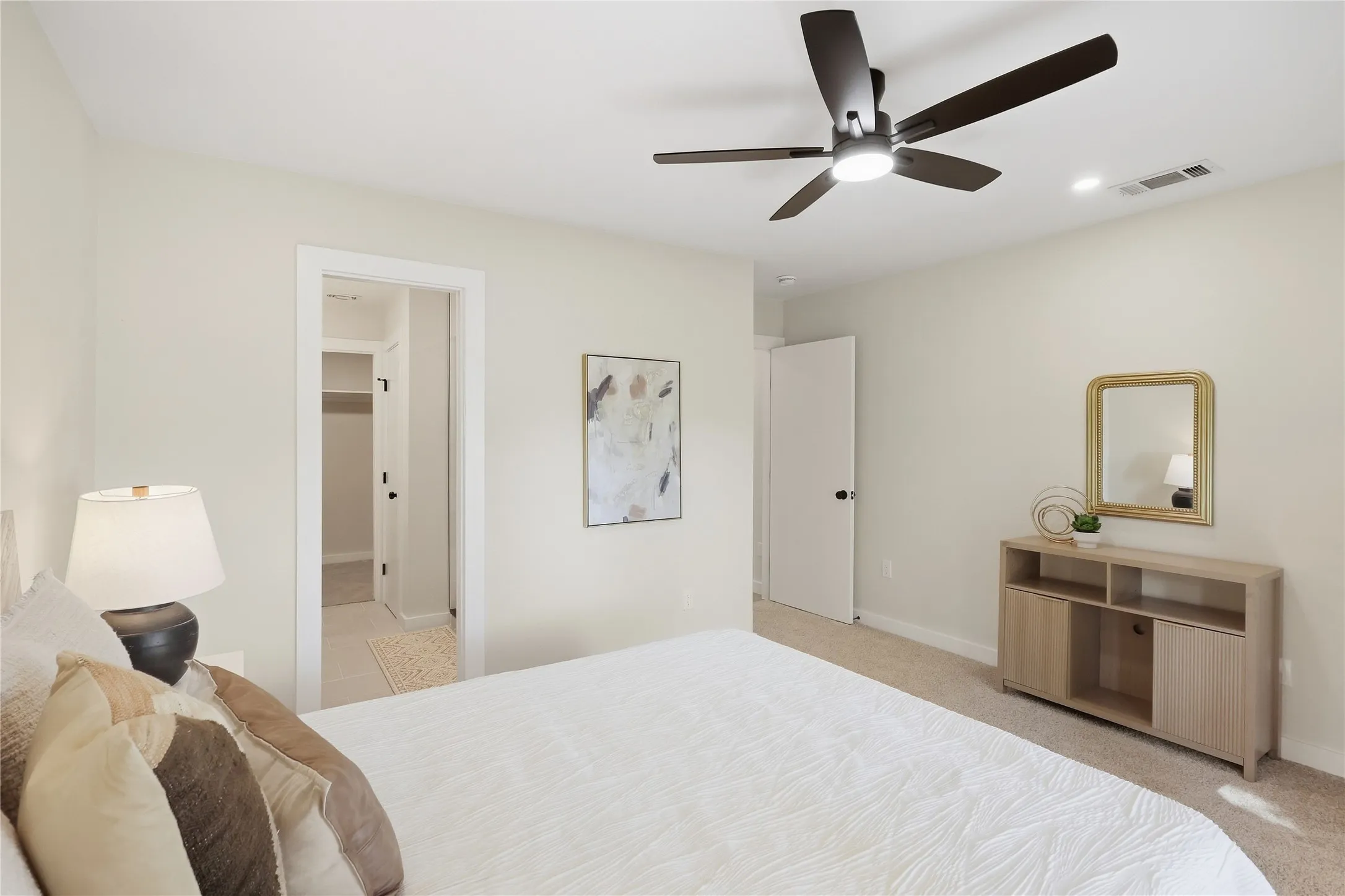 Recessed lighting, ceiling fan with integrated light, and neutral wall tones