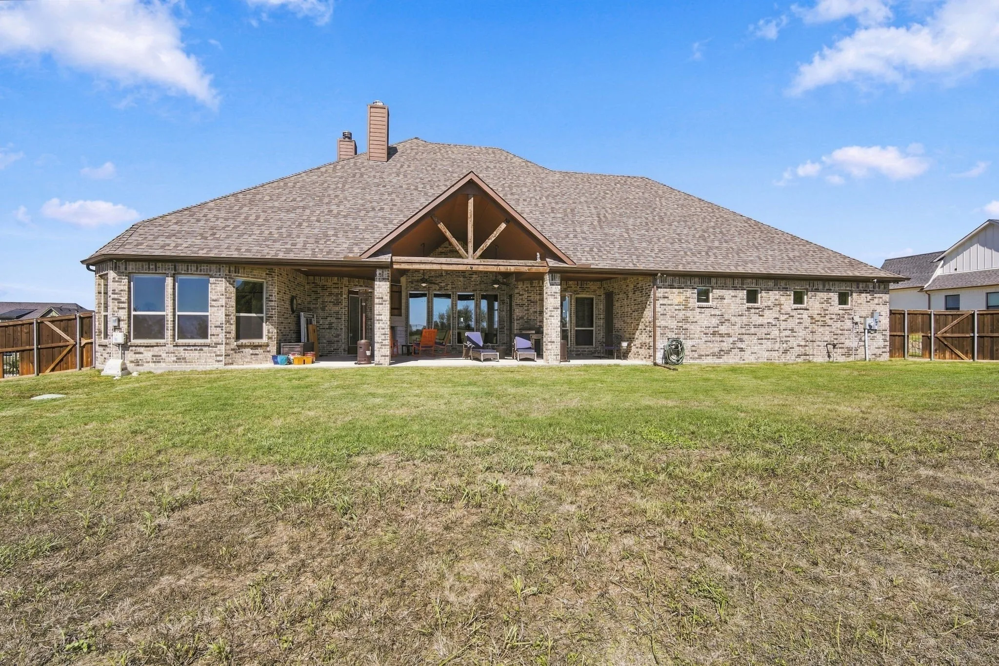 The back of the home showing off the covered porch and windows even in the garage.