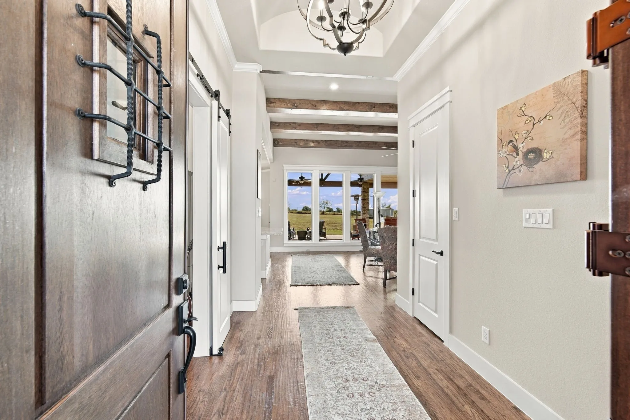 Welcome in! This spacious foyer features crown molding, a barrel ceiling, decorative lighting and hardwood flooring.