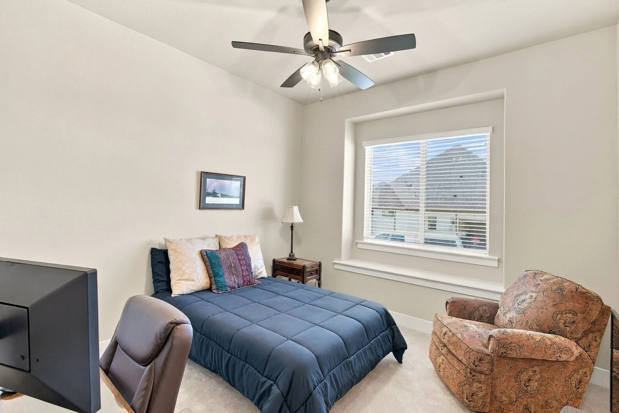 Bedroom has a walk in closet with lighting, recessed window with a deep sill and a ceiling fan with a light.