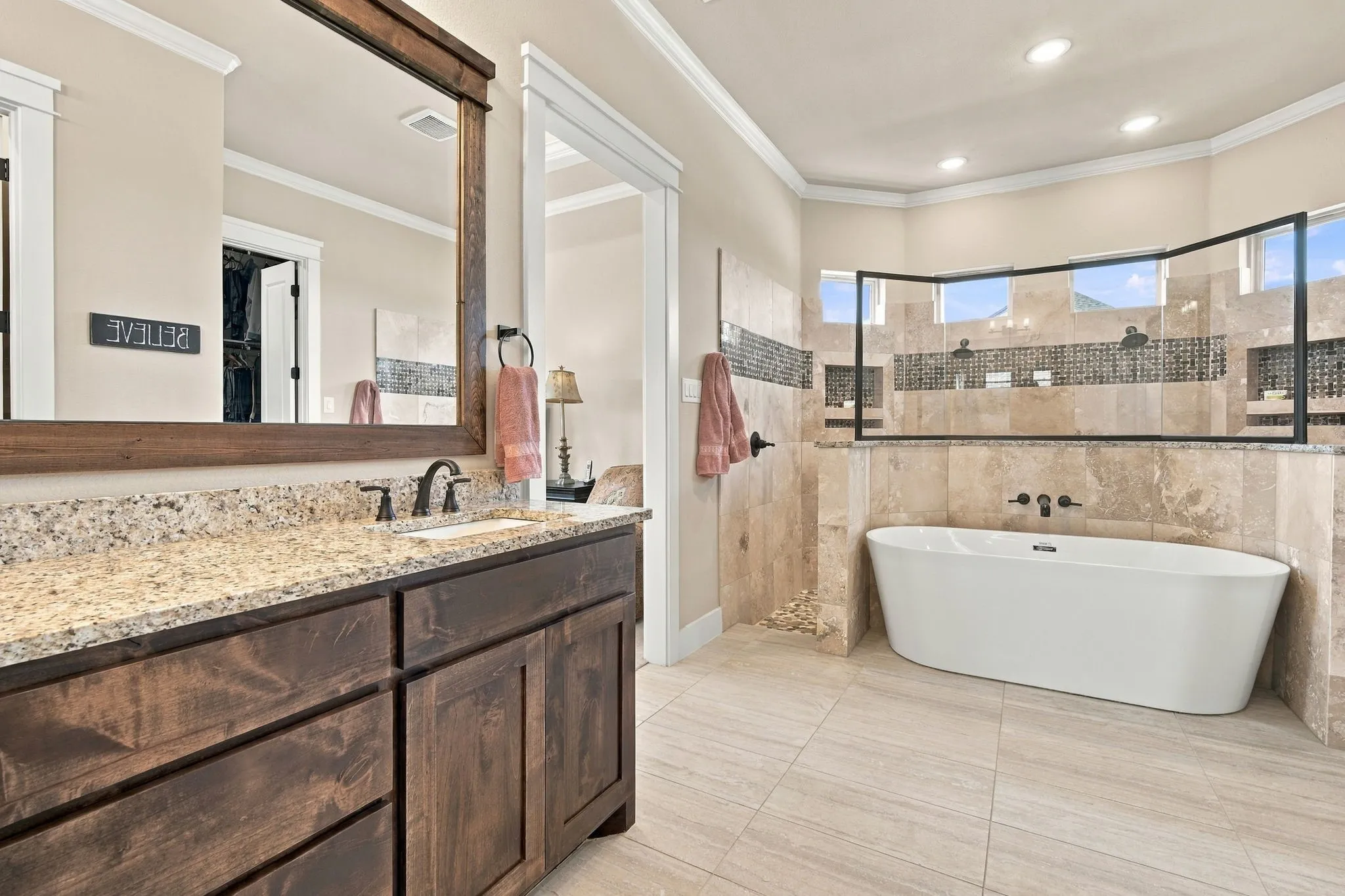 one side of the dual vanity with a framed mirror and granite counters.