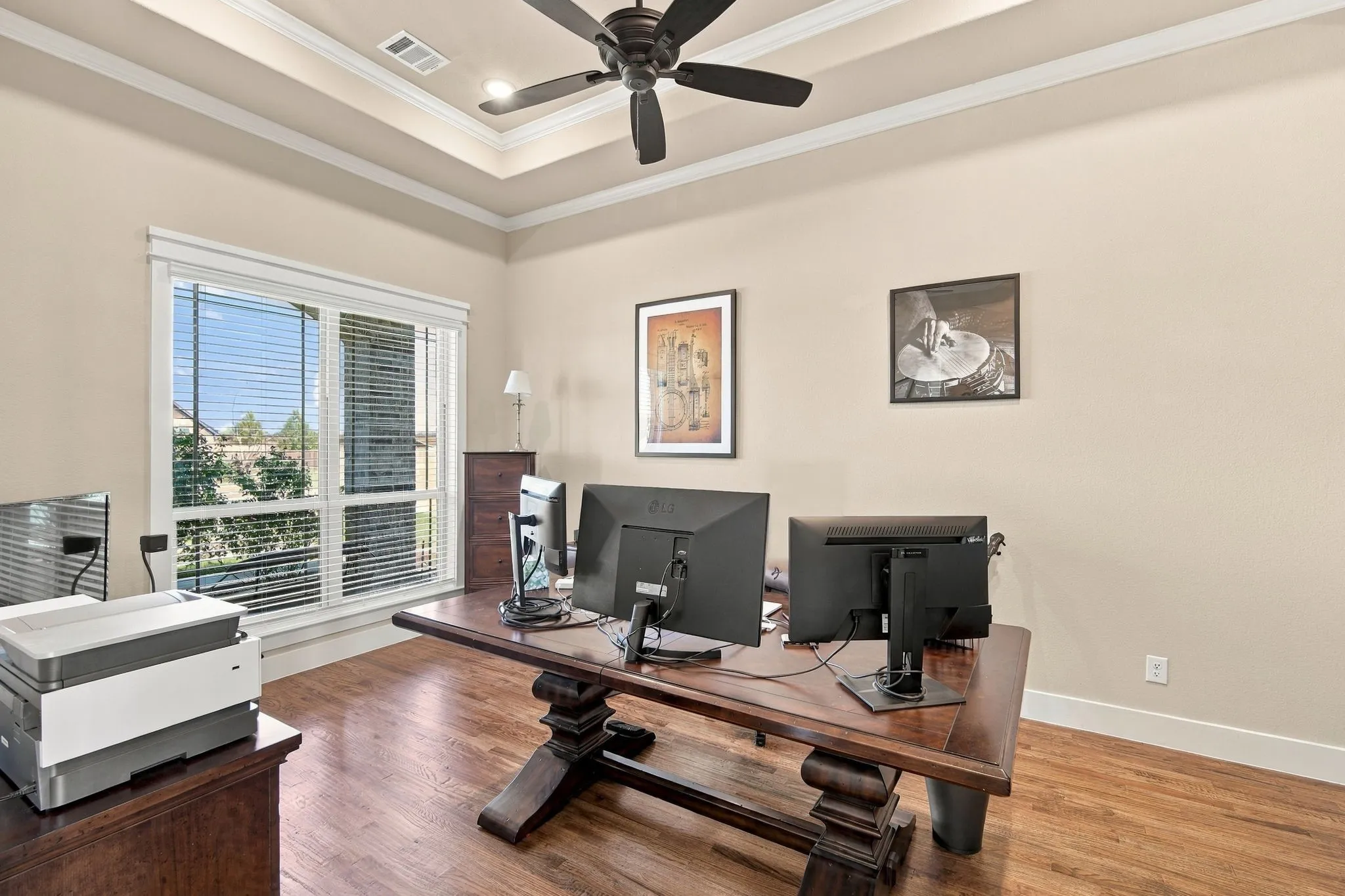 Office upgraded with a Trey ceiling, double crown molding, wood flooring, wider baseboards and a ceiling fan.