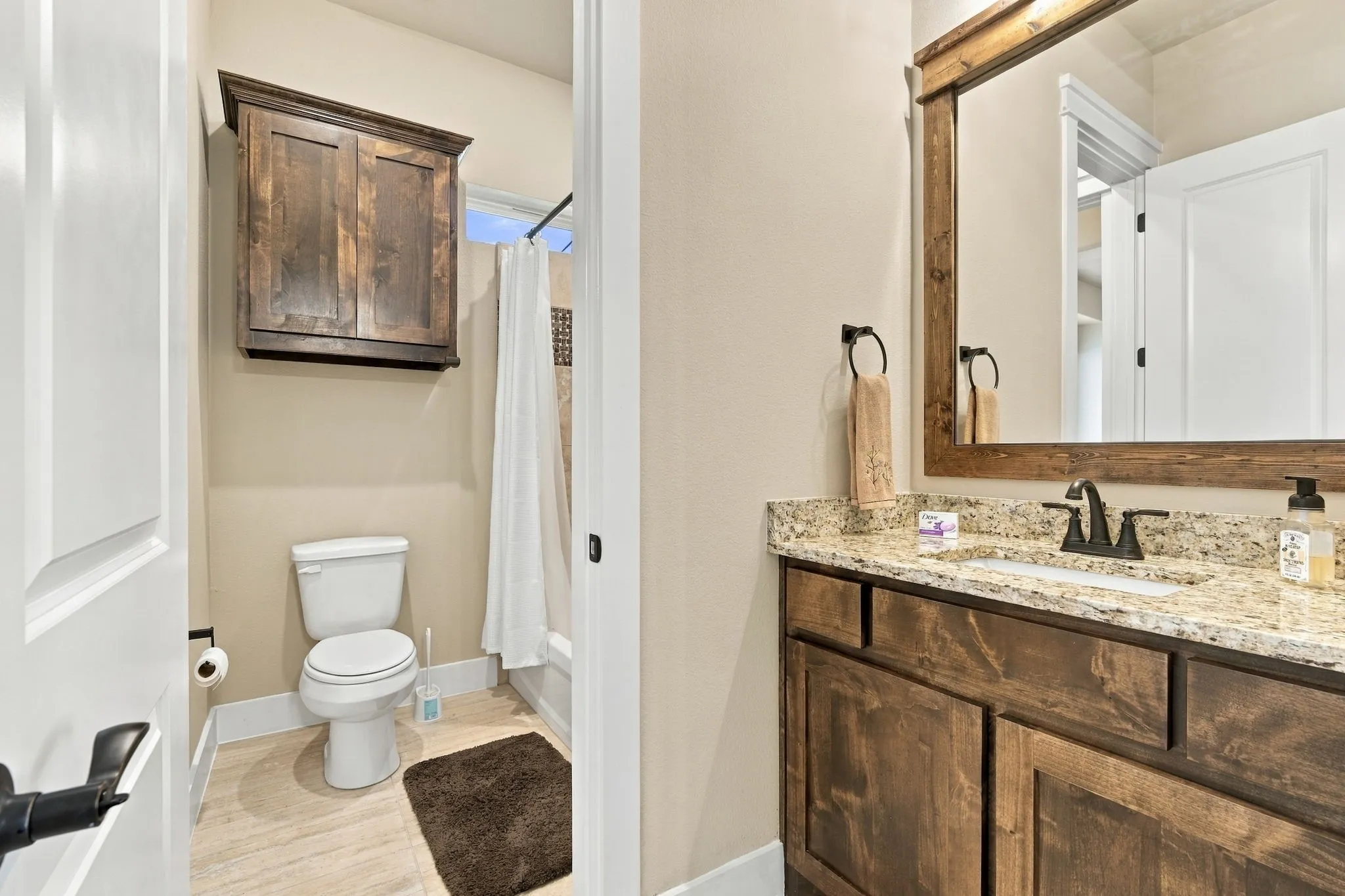 Other half of Jack and Jill bath, undermount sink, tile flooring and framed mirror.