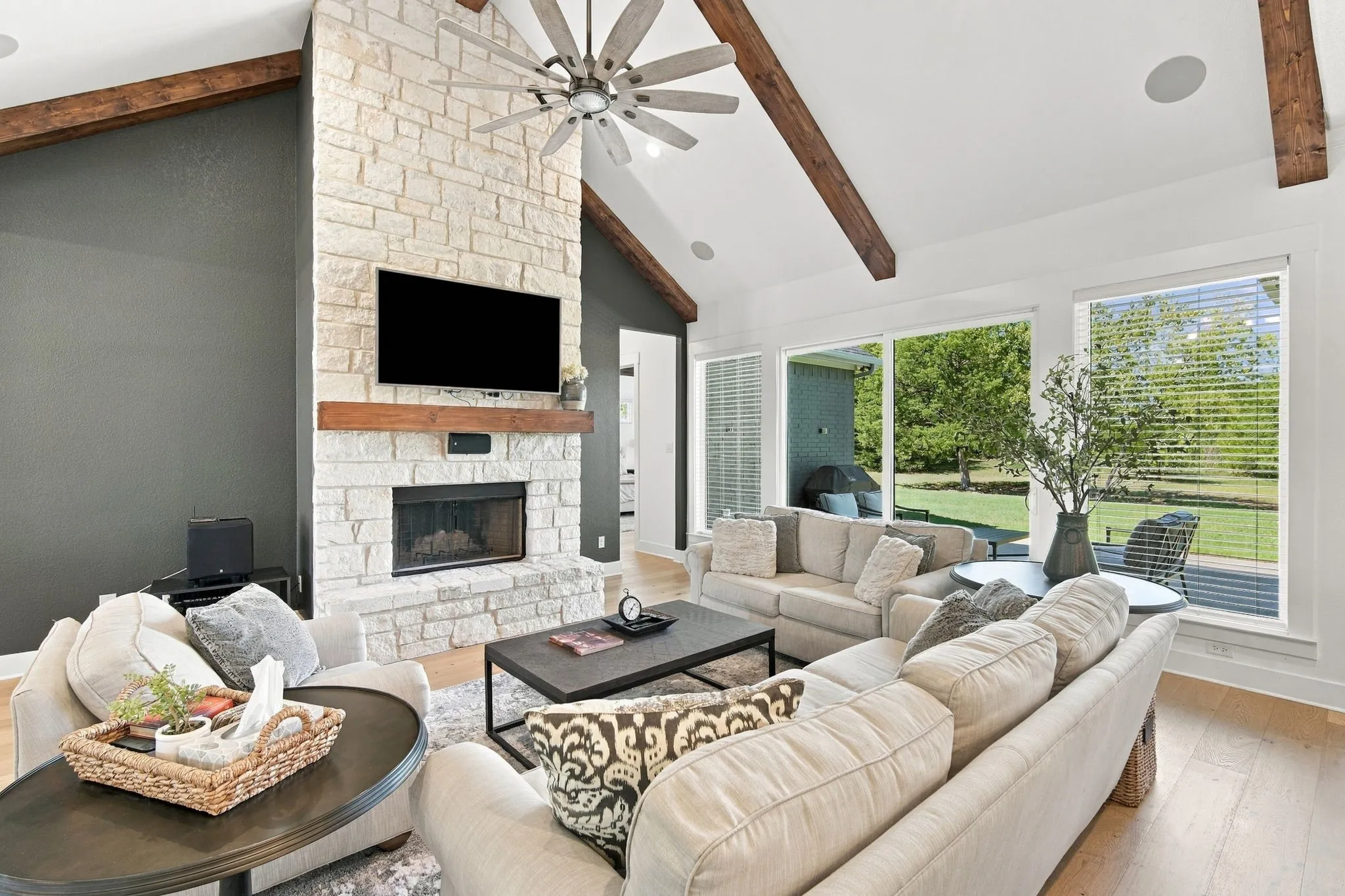 This space is warm with the stone floor to ceiling fireplace and cedar mantle. Cool Farmhouse style fan. Great view of the treed yard.
