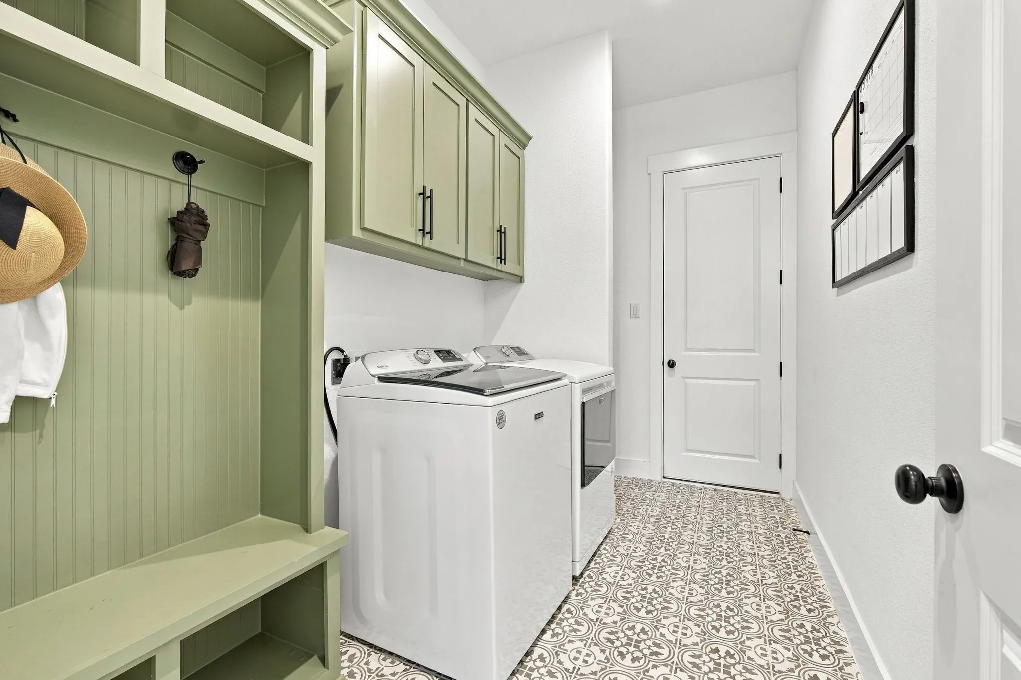 Built-in mud bench with a beadboard accent, patterned tile flooring, built in cabinets and open shelving behind the wall offer great storage here.