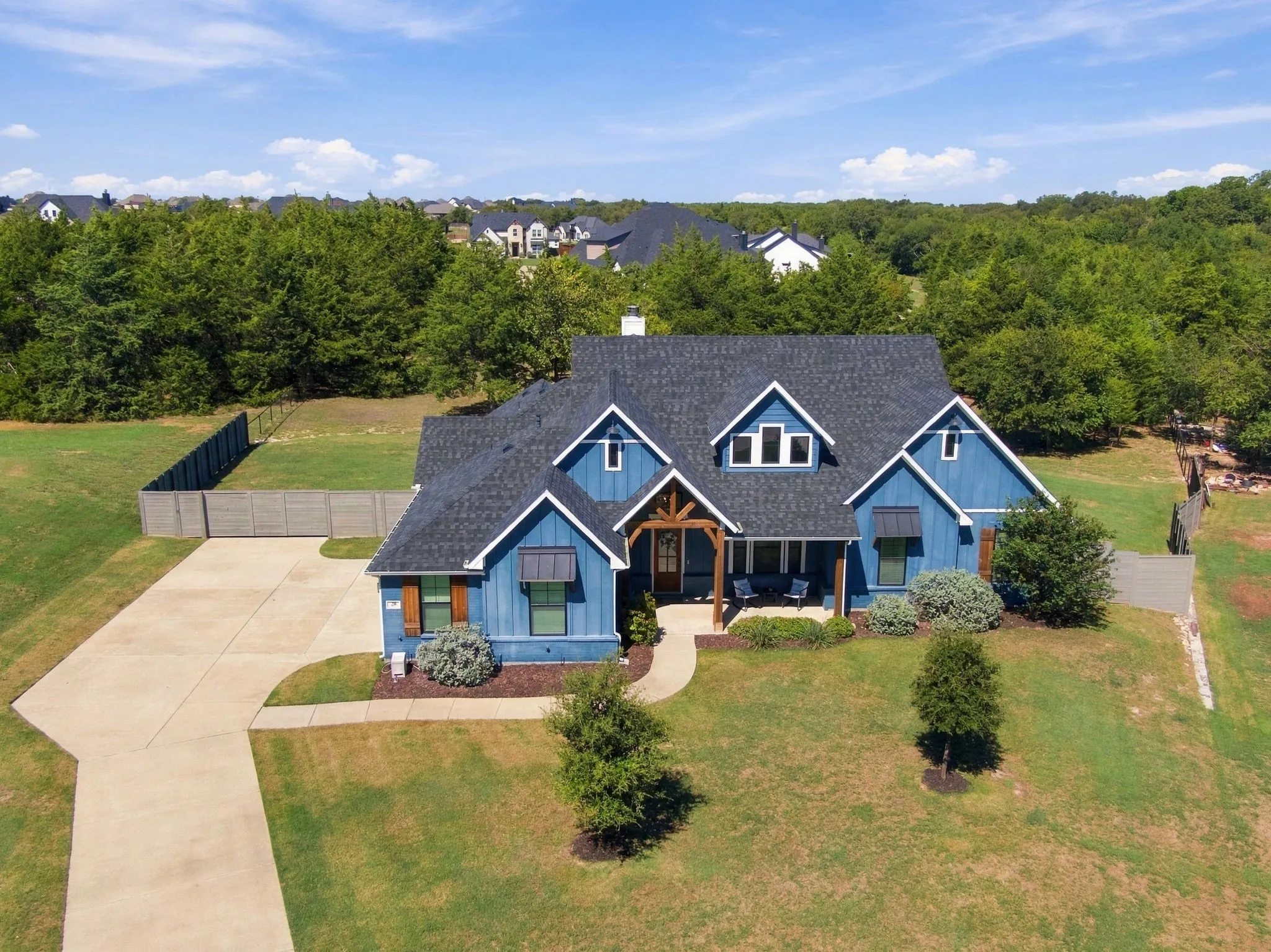 The cedar accents pop against the blue. Privacy wood fence with a good sized gate.