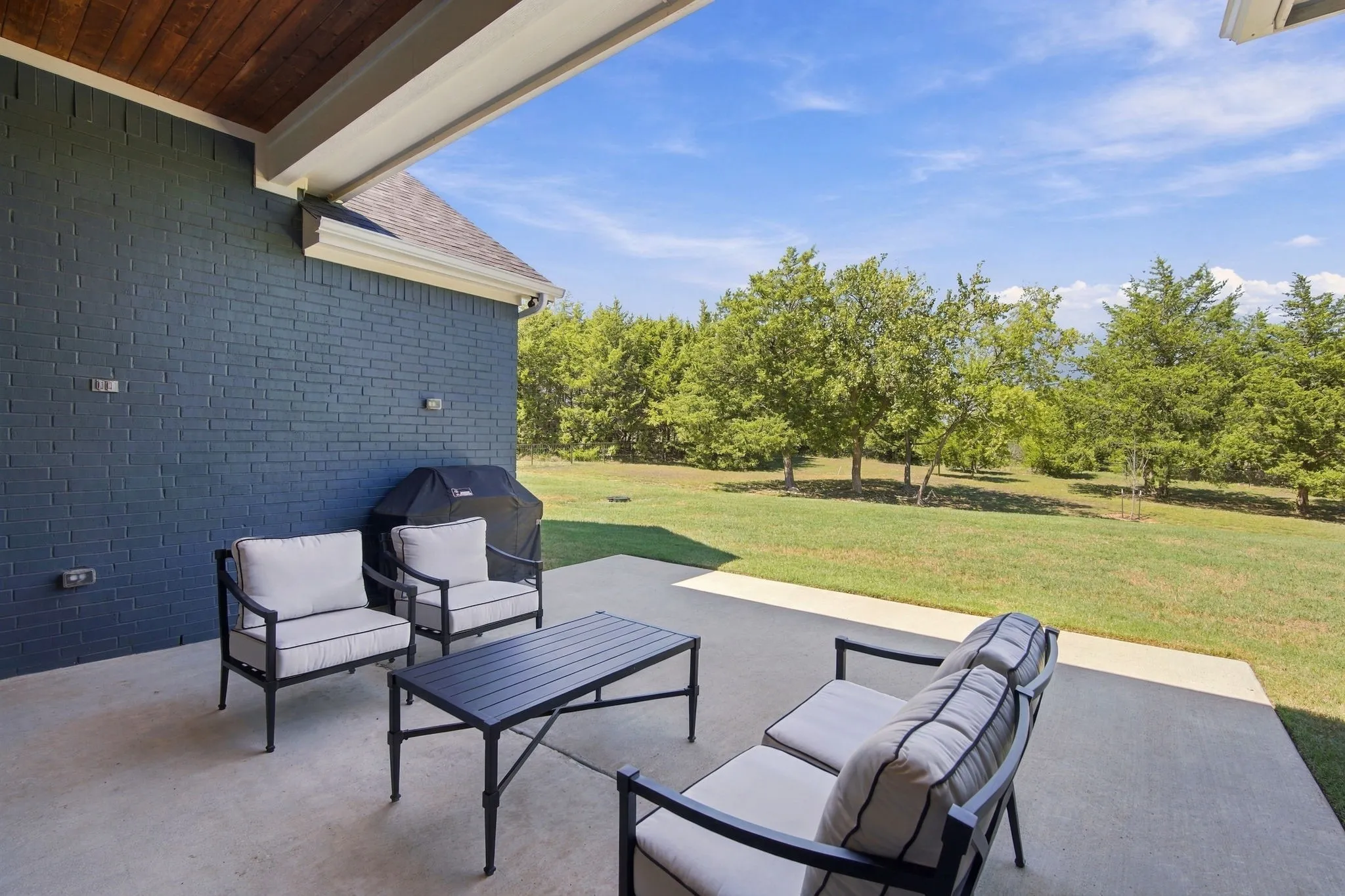 Covered patio with a wood-finish ceiling  and the concrete was extended.