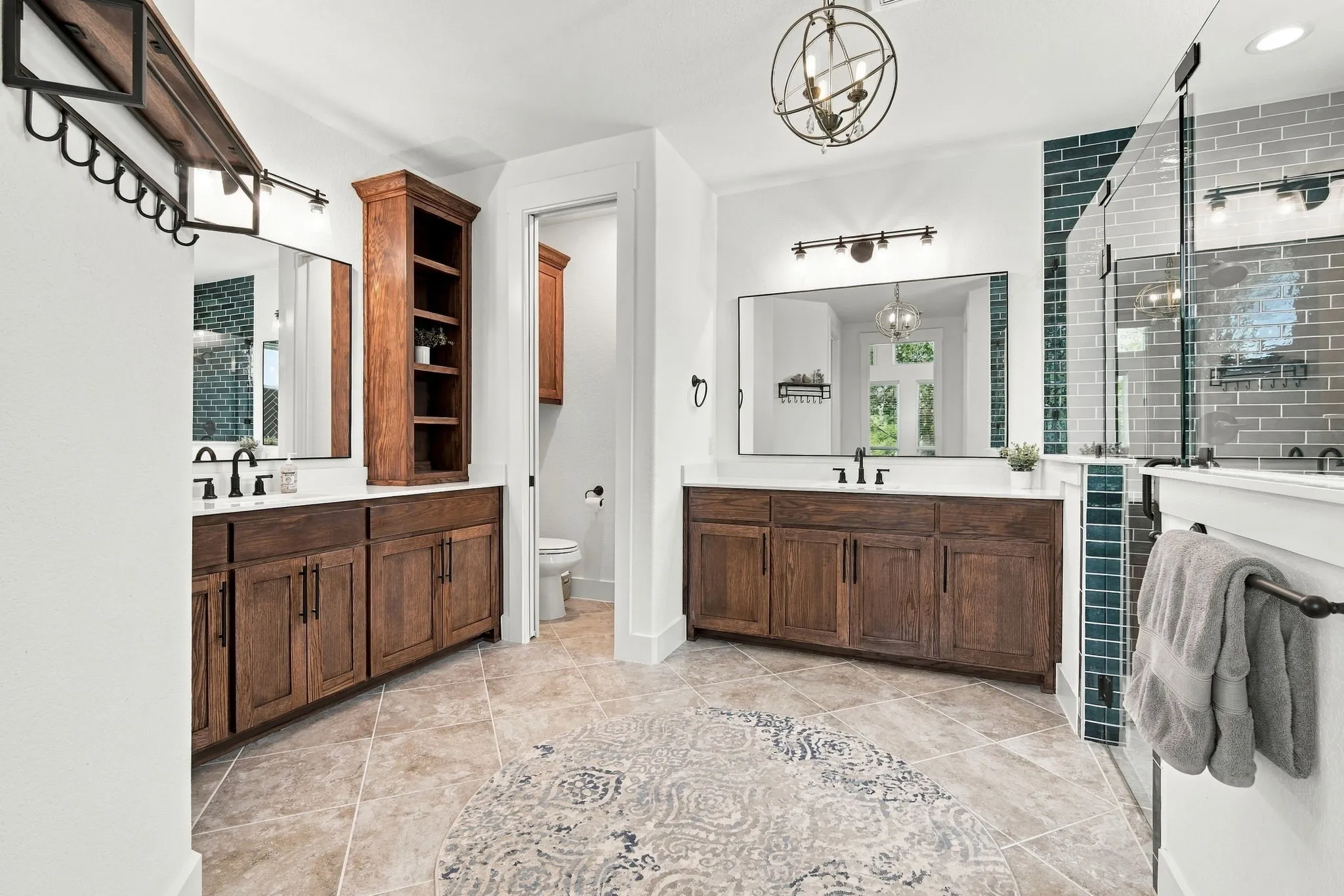 Separate vanities with frameless mirrors make getting ready a breeze. Warm color on the wood cabinetry adds warmth to the space.