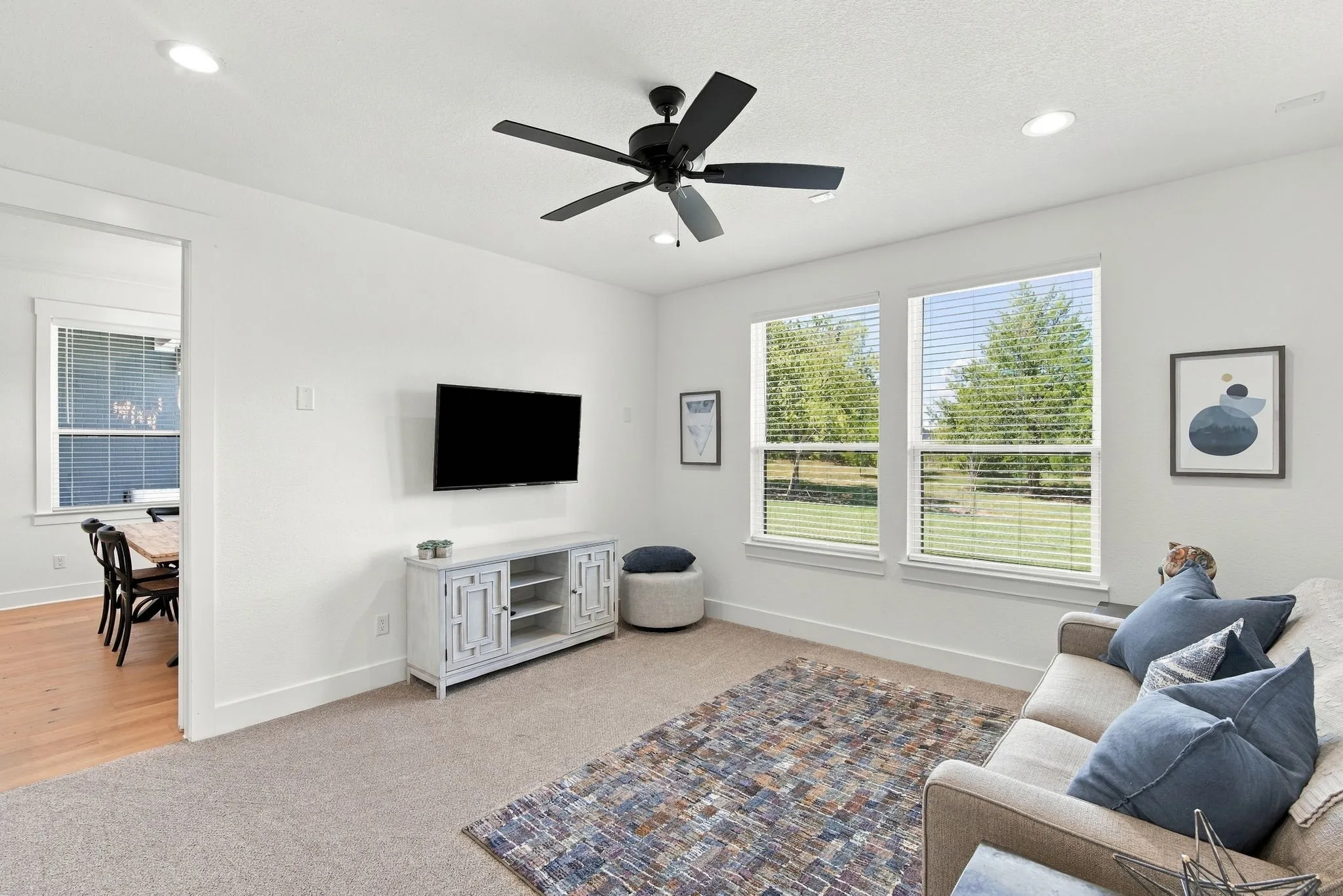 Notice the Recessed lighting, a black ceiling fan and multiple windows.
