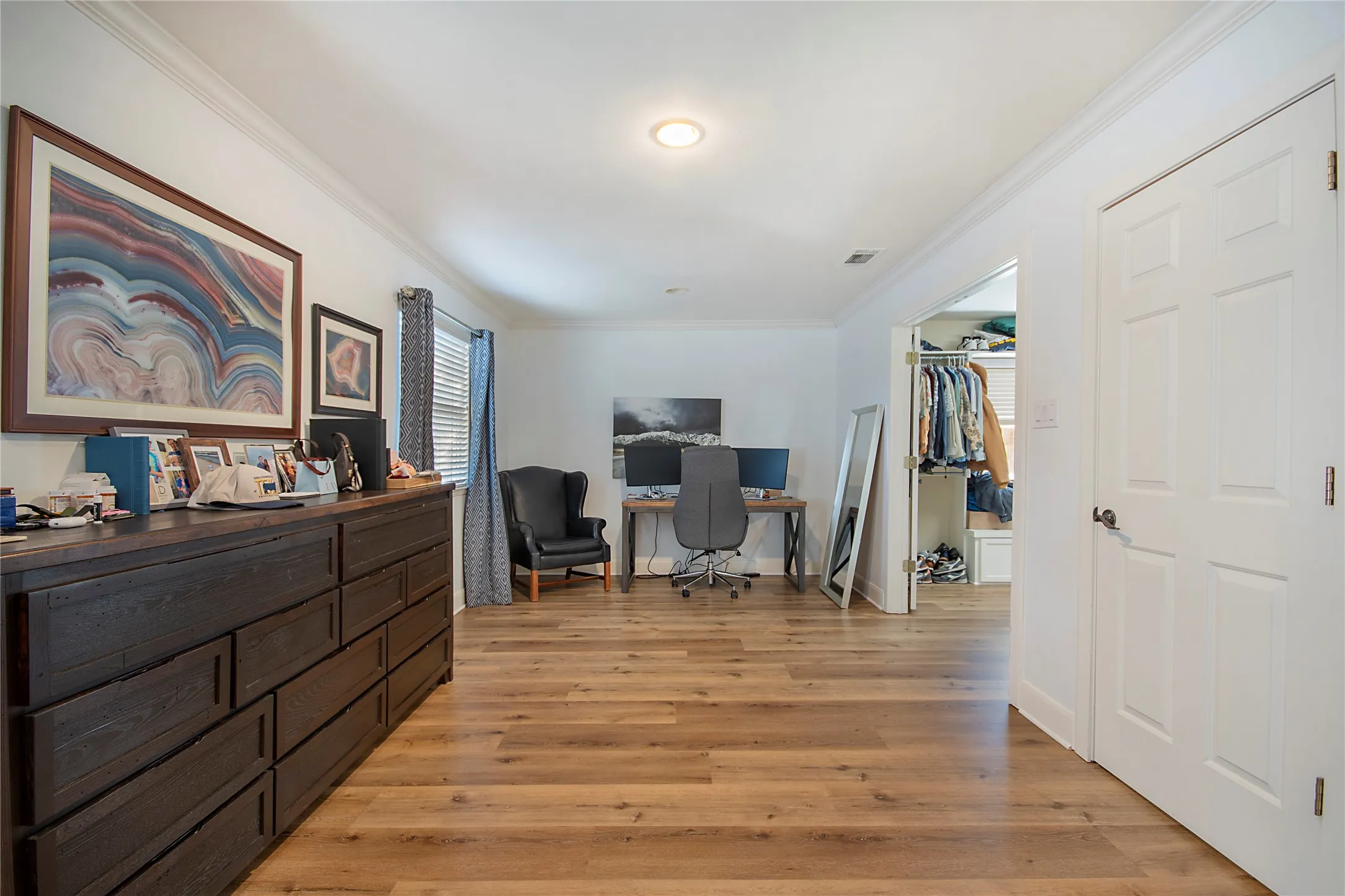 Wood-finish flooring throughout, crown molding detail, recessed lighting, and a six-panel door
