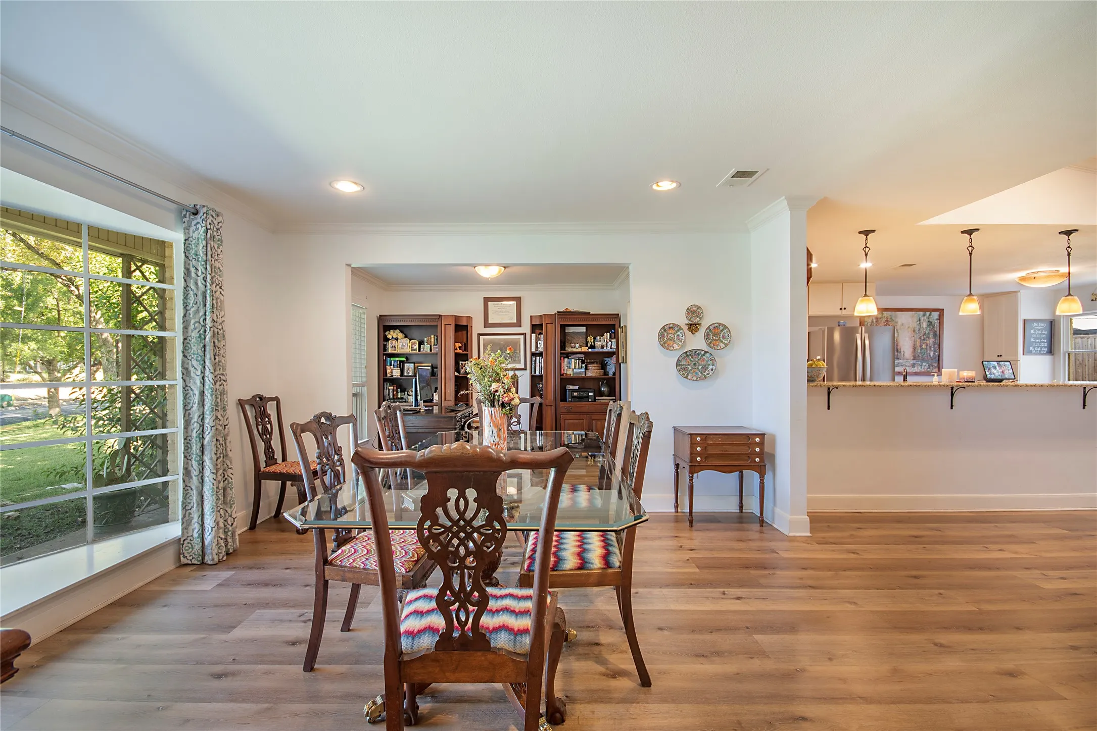 Wide plank wood-finish flooring, recessed lighting, and a bay window