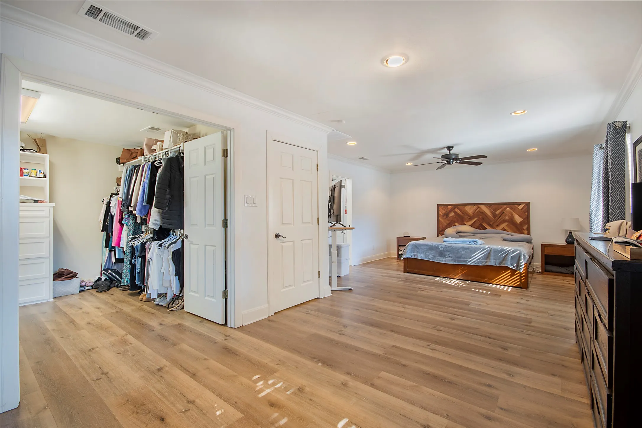 Spacious interior with wood-finish flooring, recessed lighting, ceiling fan, and crown molding