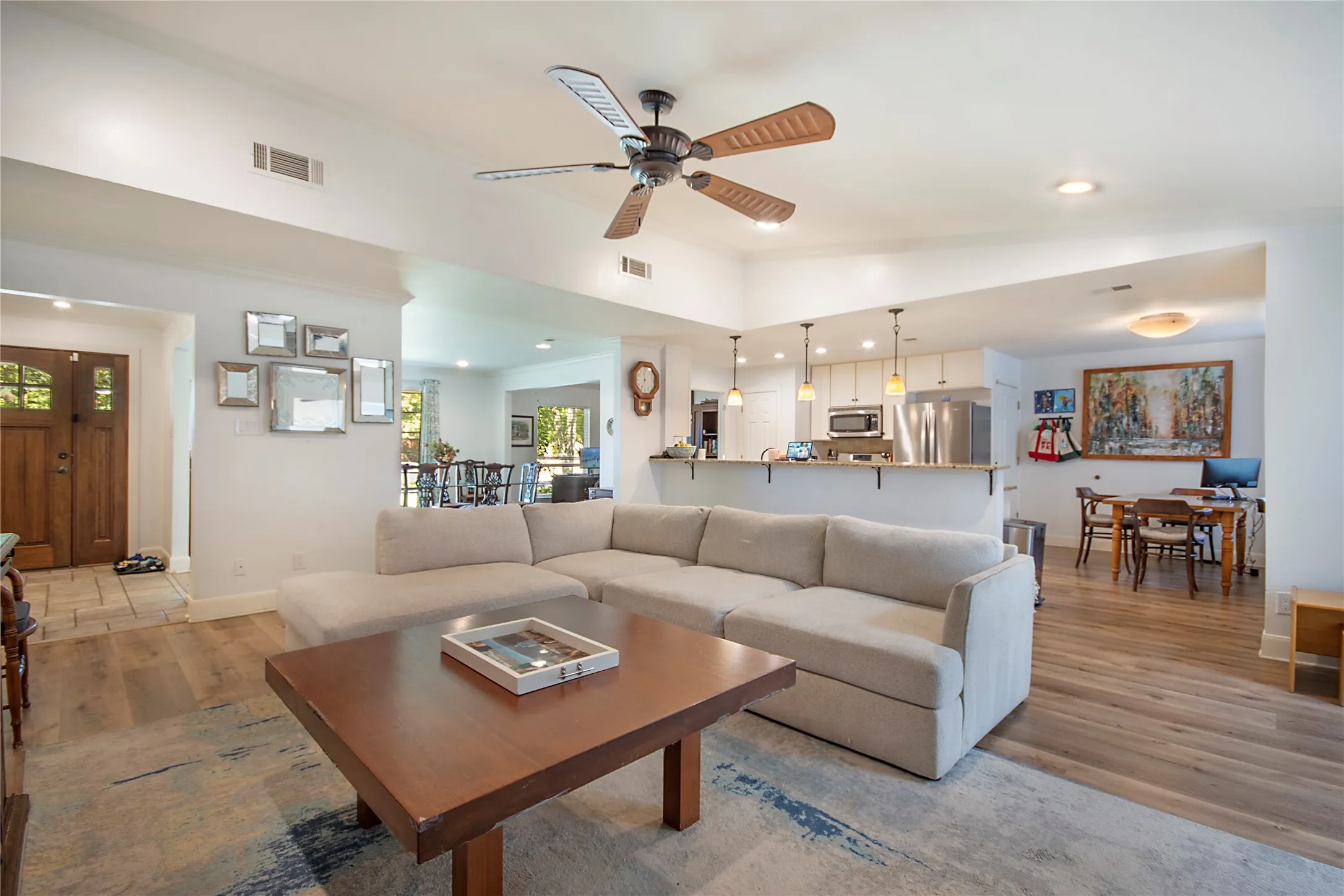 Open-concept living area featuring a sectional-ready layout with hardwood flooring throughout