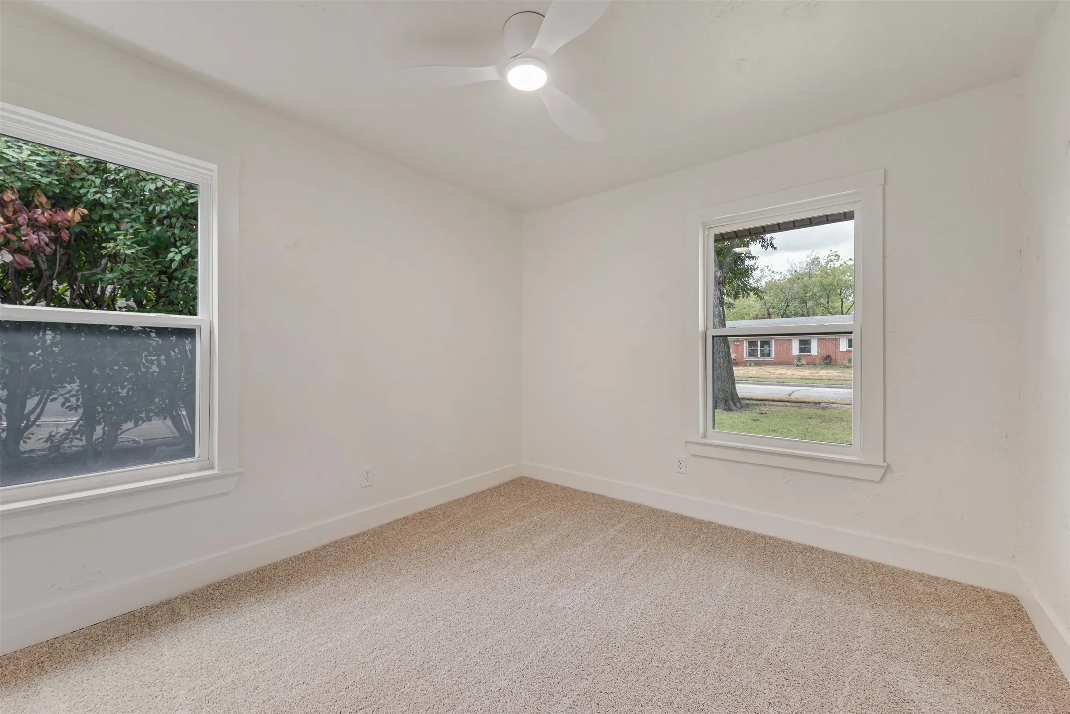 Spacious secondary bedroom with new carpet and dual windows.