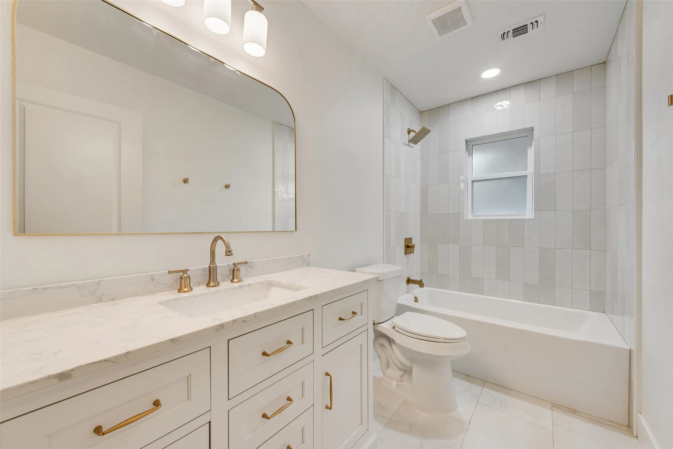 Second full bath with extended vanity and tub-shower combination.