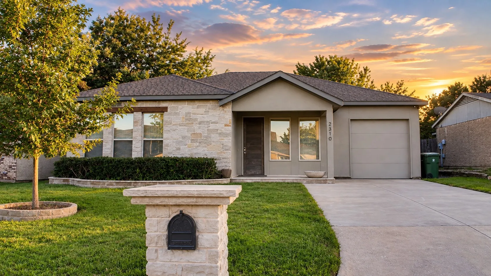 Single-story residence featuring a stone and stucco exterior, attached garage, and a concrete driveway