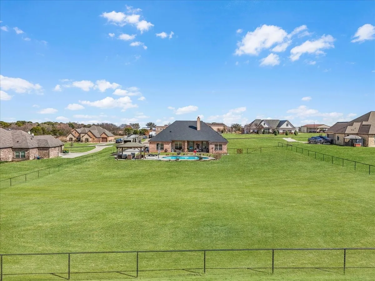 Expansive fenced backyard offering wide-open green space, scenic surroundings, and plenty of room for outdoor activities and recreation.