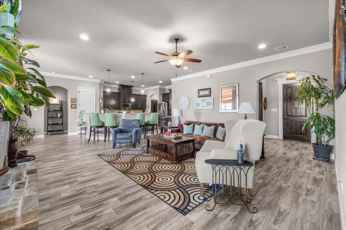 Open Living Area: Expansive open-concept layout creates an easy flow between the living room and kitchen, complemented by high ceilings, recessed lighting, and consistent flooring.