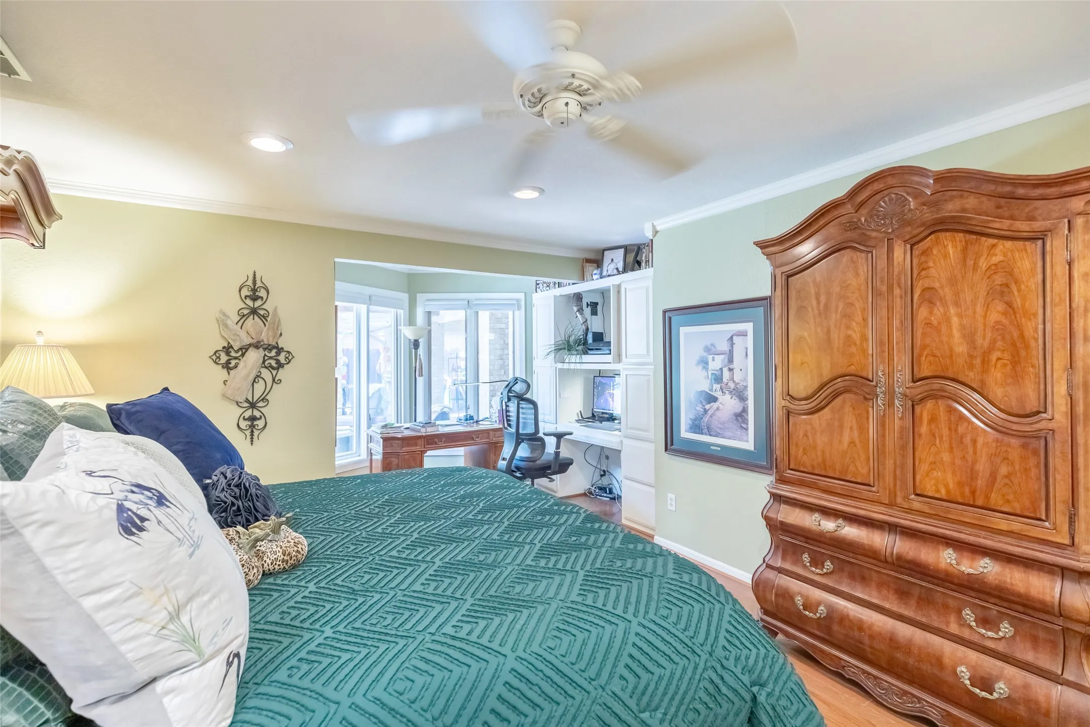 Tray ceiling with a ceiling fan, recessed lighting, wood-finish flooring, and a bay window