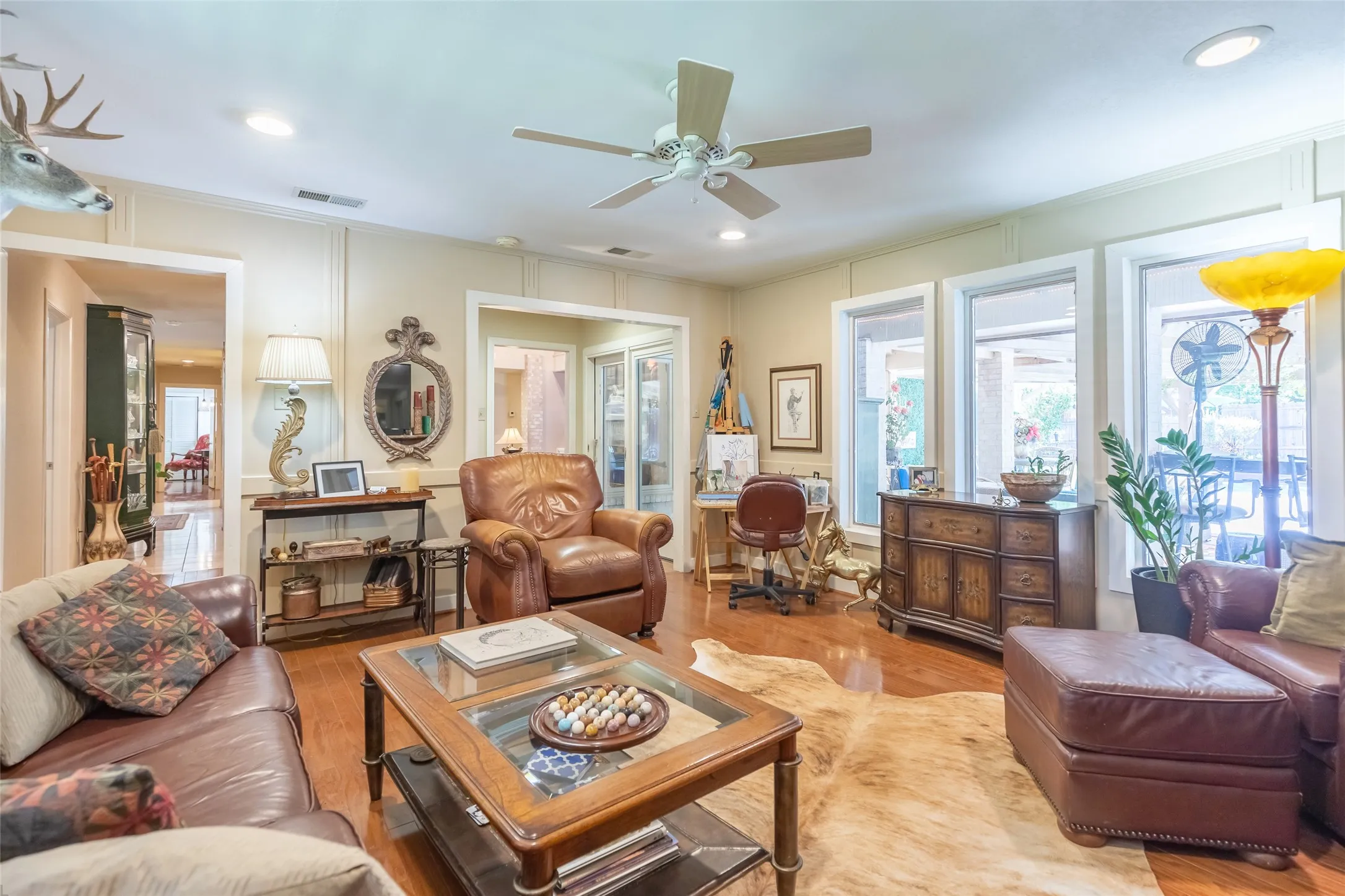 Hardwood flooring, recessed lighting, ceiling fan, multiple windows, and a glass-paneled door