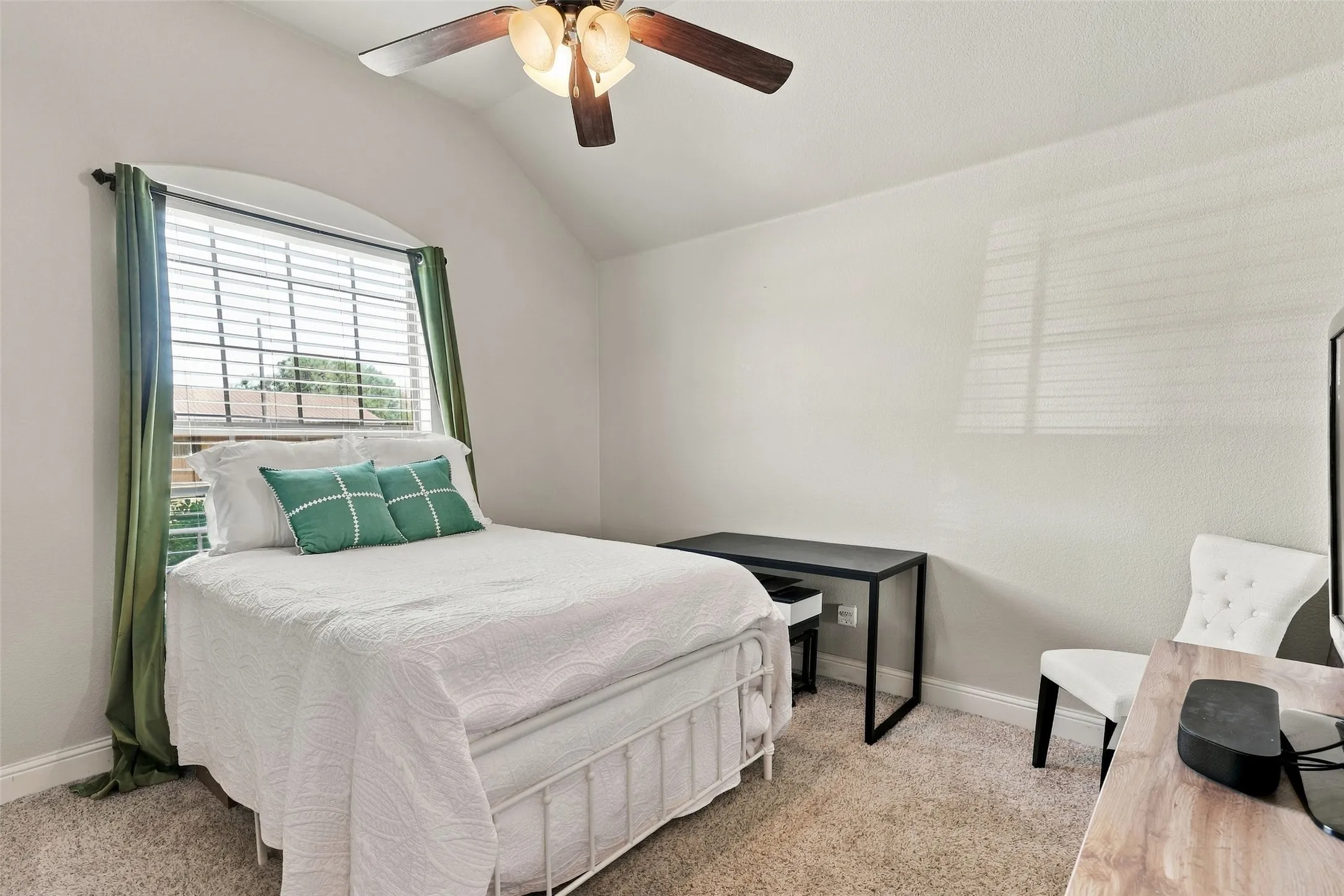 Secondary Bedroom: Bright, versatile bedroom features a vaulted ceiling, arched window, neutral finishes, and space for a desk or additional furnishings.