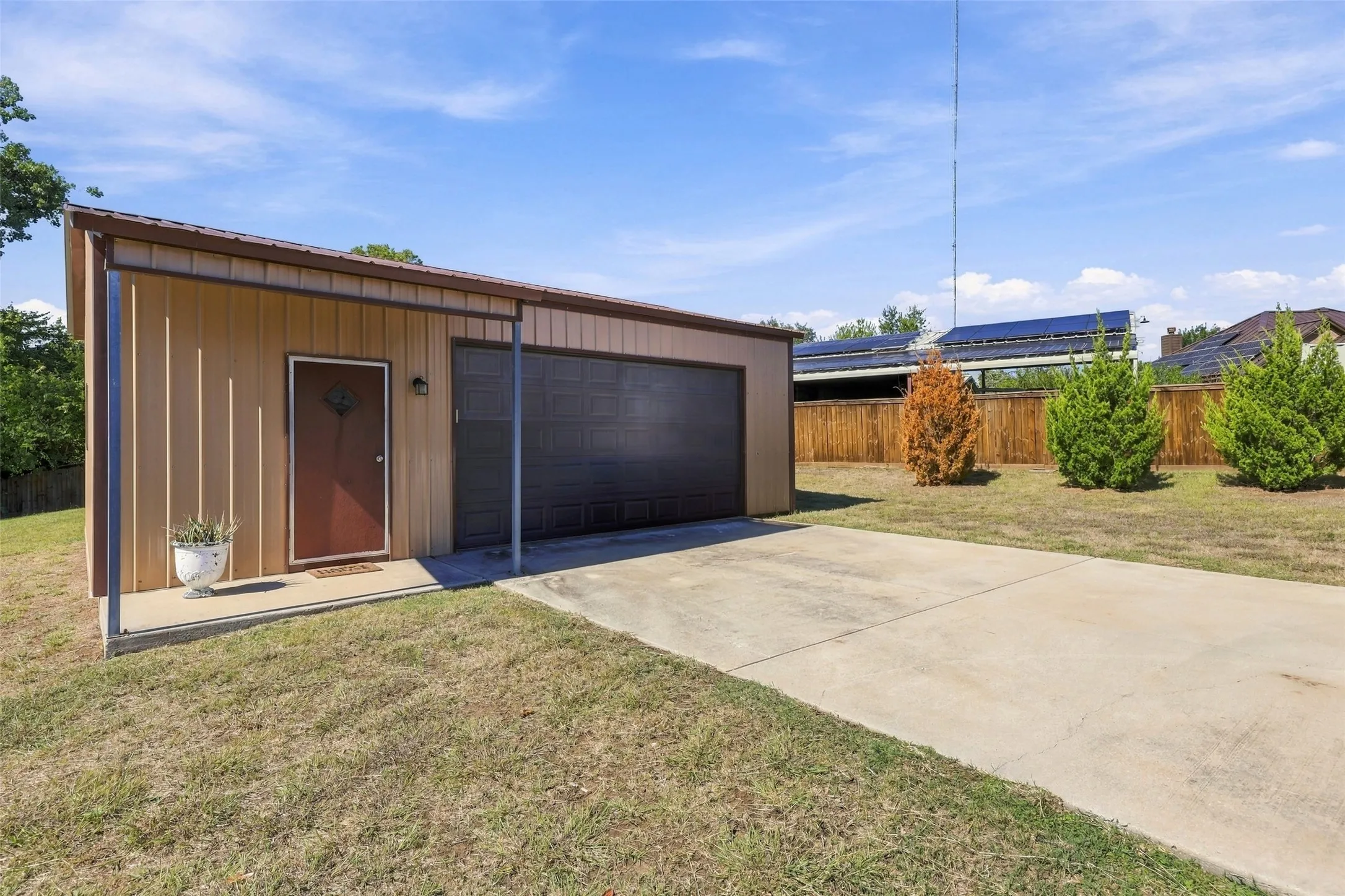 Workshop: Features a large overhead door, separate entrance, metal exterior, and concrete driveway.