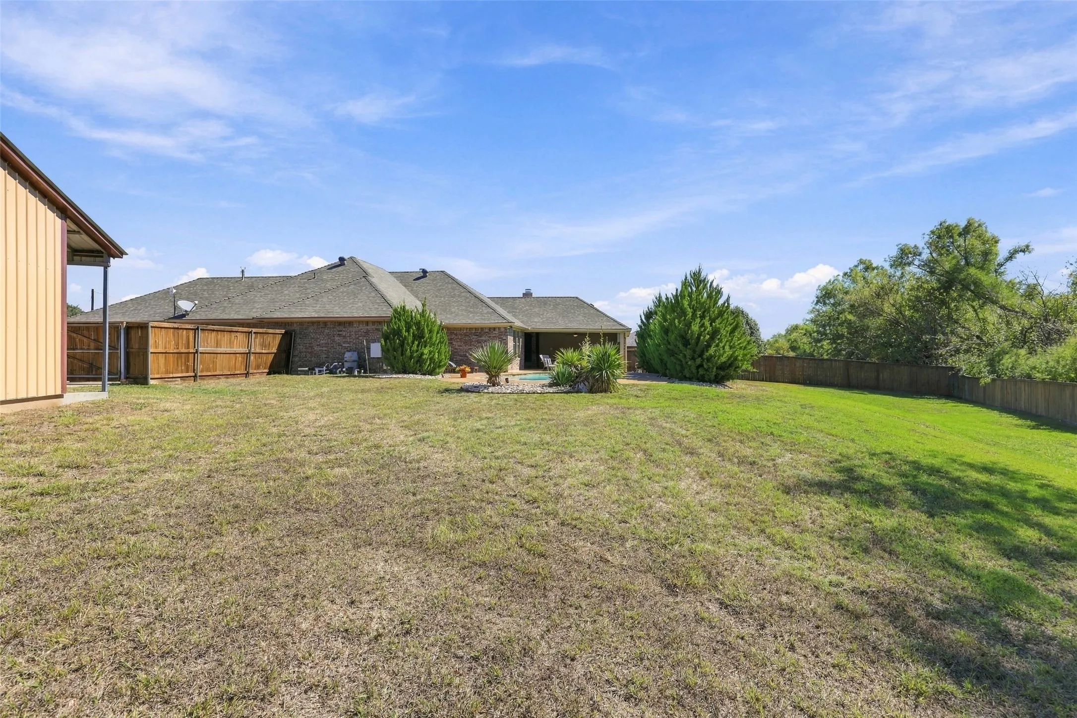Backyard: Expansive fenced backyard provides generous green space, mature trees, established landscaping, and room for a variety of outdoor activities.