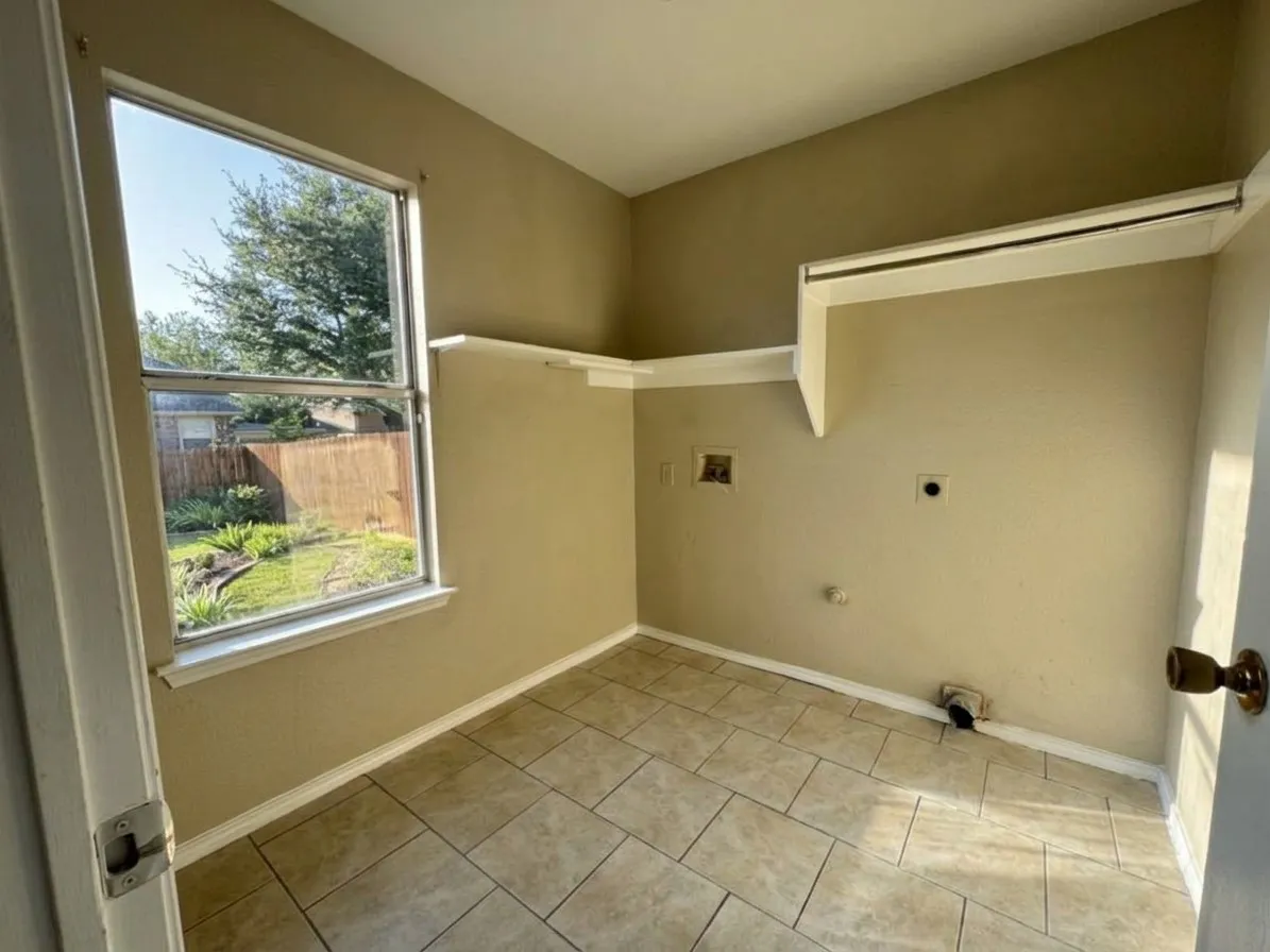 Tiled flooring, built-in shelving, and a large window