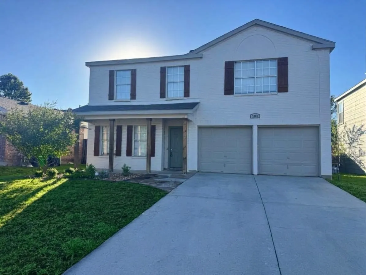 Two-story exterior with a covered porch, a two-car garage, and a concrete driveway