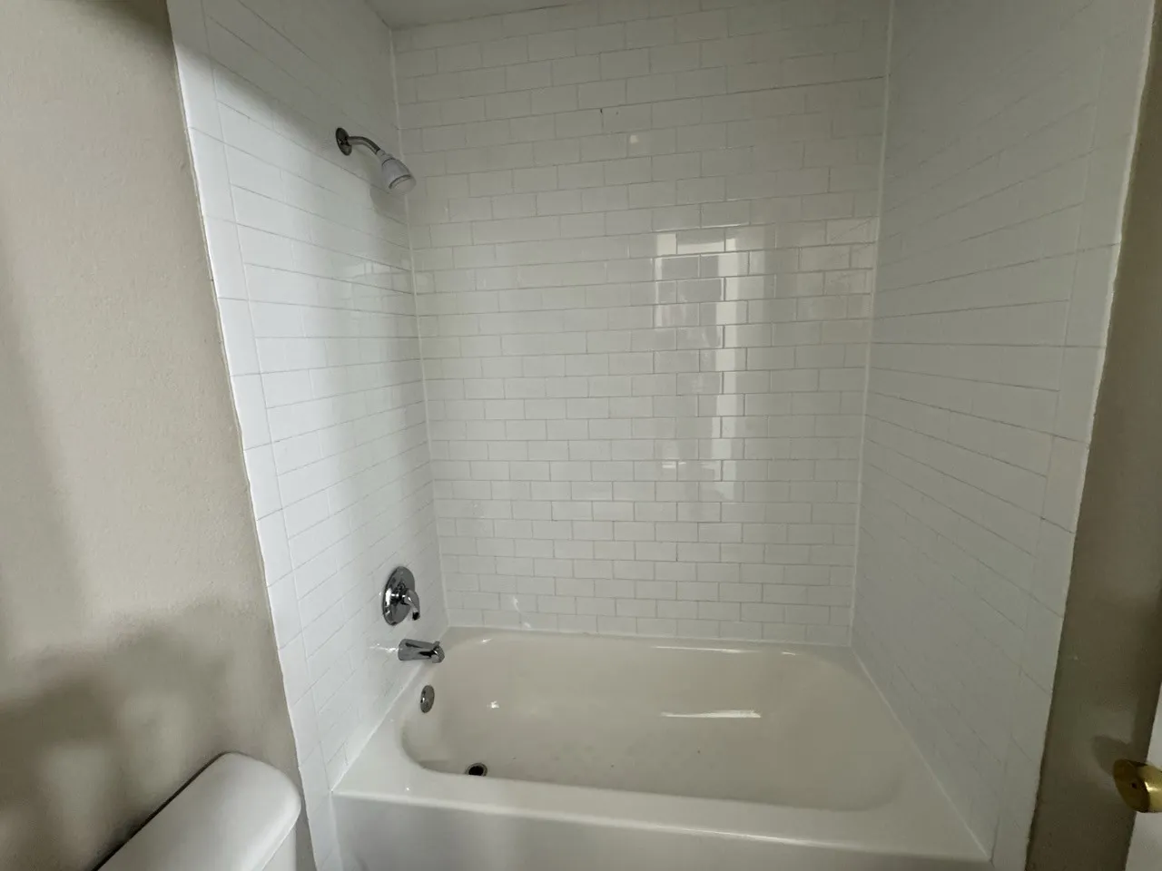 Upstairs bathroom with White subway tile shower surround with a built-in tub and polished chrome fixtures