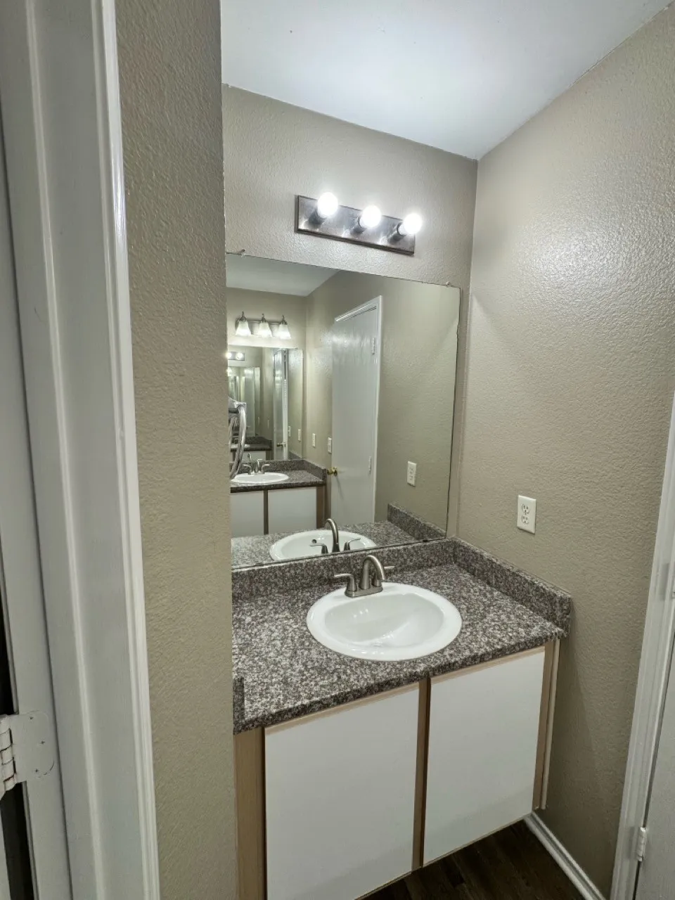 Upstairs bathroom Vanity with an integrated sink, granite-style countertop, and a large wall mirror