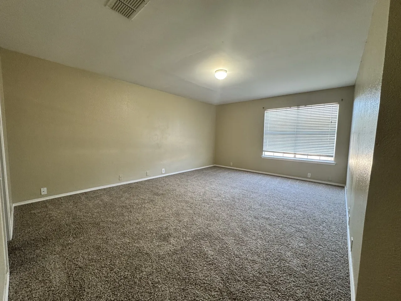 Carpeted flooring, neutral wall tones, recessed ceiling light, window with blinds