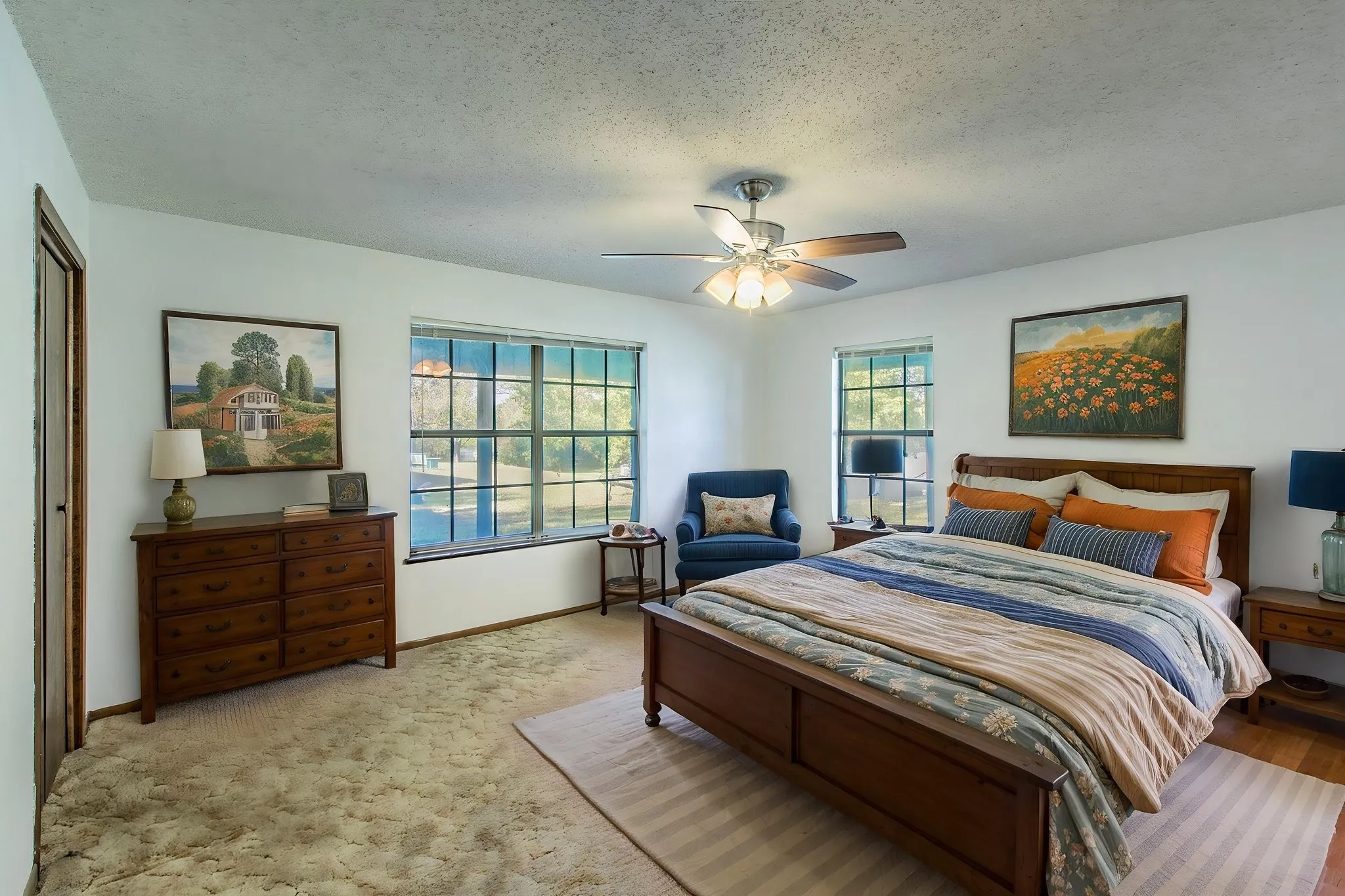 Ceiling fan with light fixture, multiple windows in this spacious bedroom