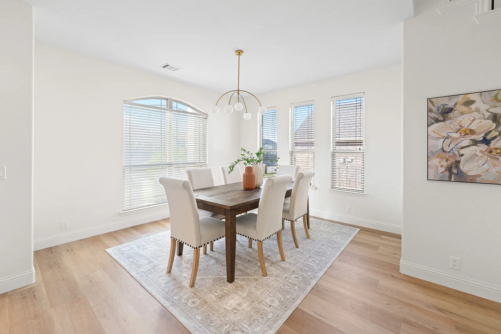 Recessed lighting, light wood-finish flooring, arched window, multiple windows, and a contemporary chandelier